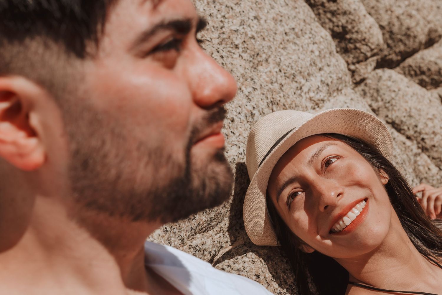Romantic beach photoshoot showing couple laying on sandy shore.