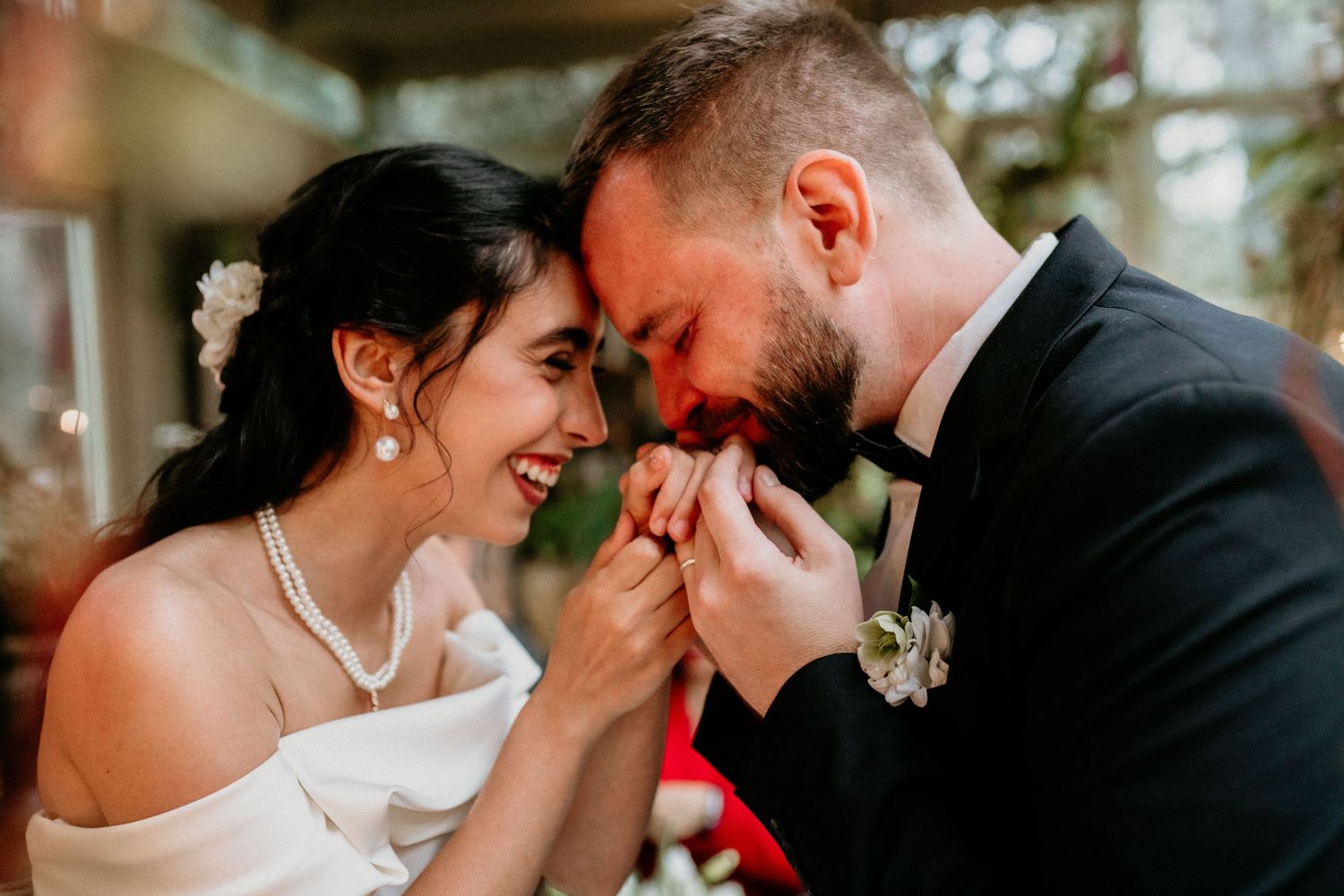 A romantic moment shared between newlyweds at a wedding as they lean in close and smile together.