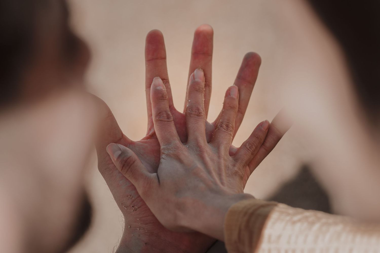 Artistic black and white photo of hands reaching out against dark background.