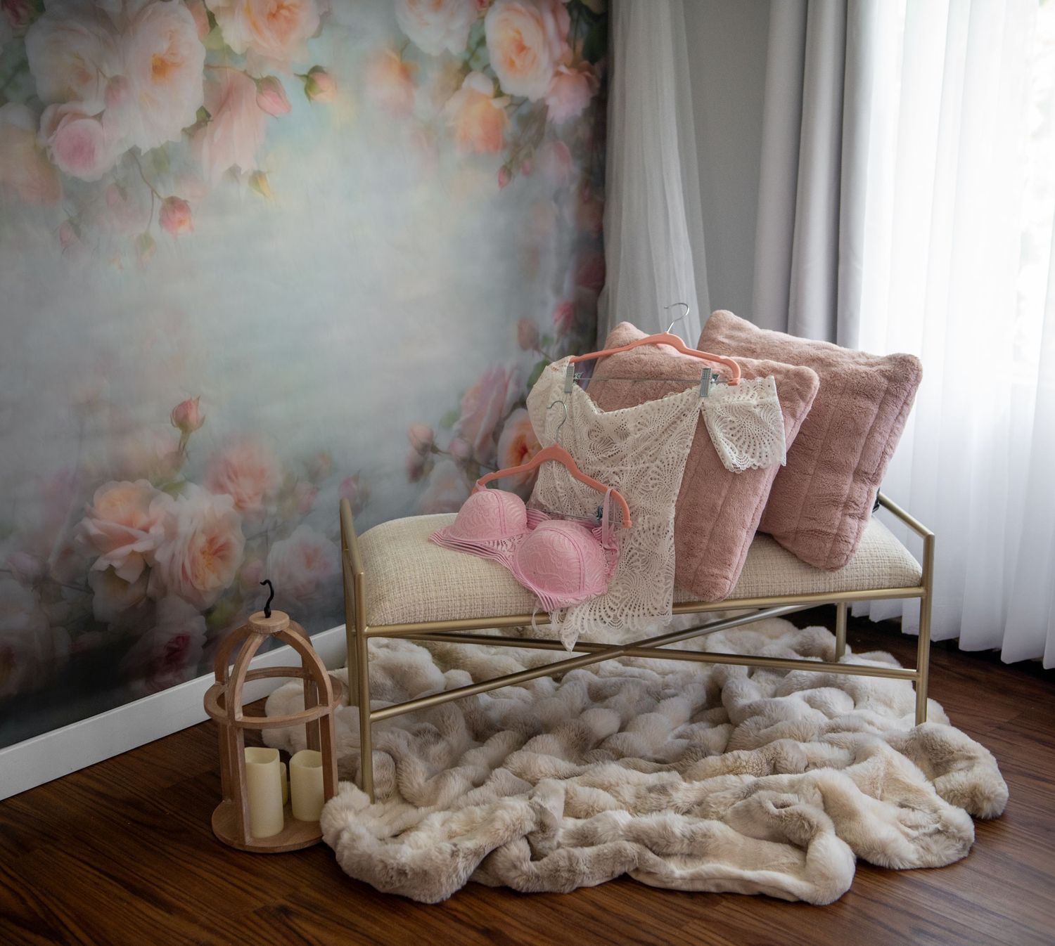 Elegant feminine sitting area set with pink floral wallpaper, velvet pillows, and cozy textured throw blanket by a window.