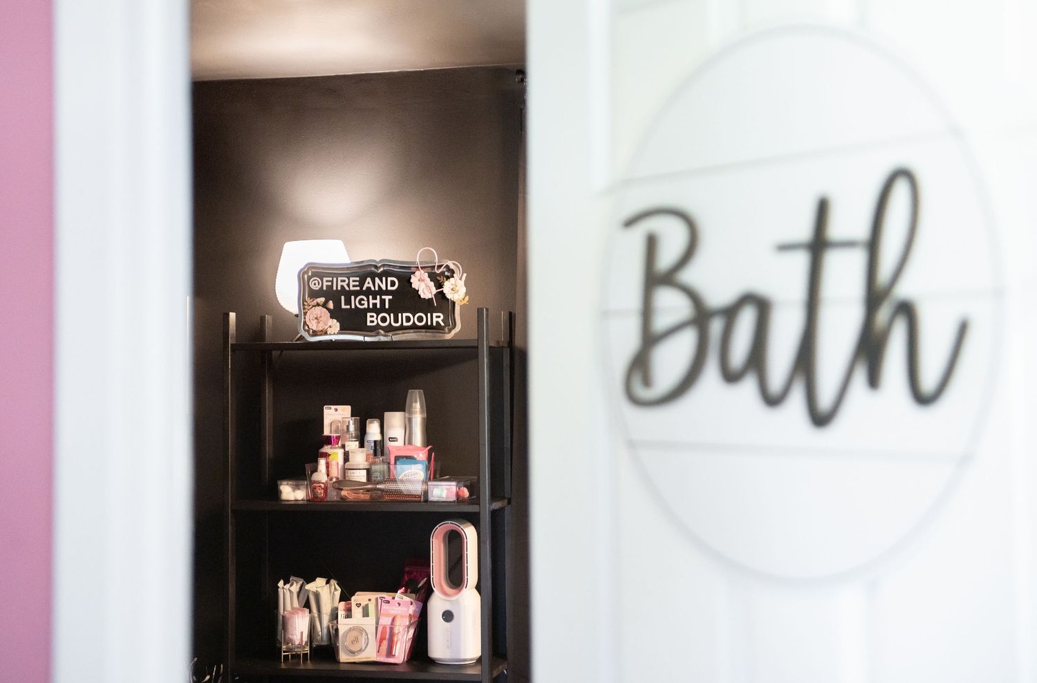 Collection of Seattle boudoir client skincare and beauty products for touch ups displayed on shelves with black background.