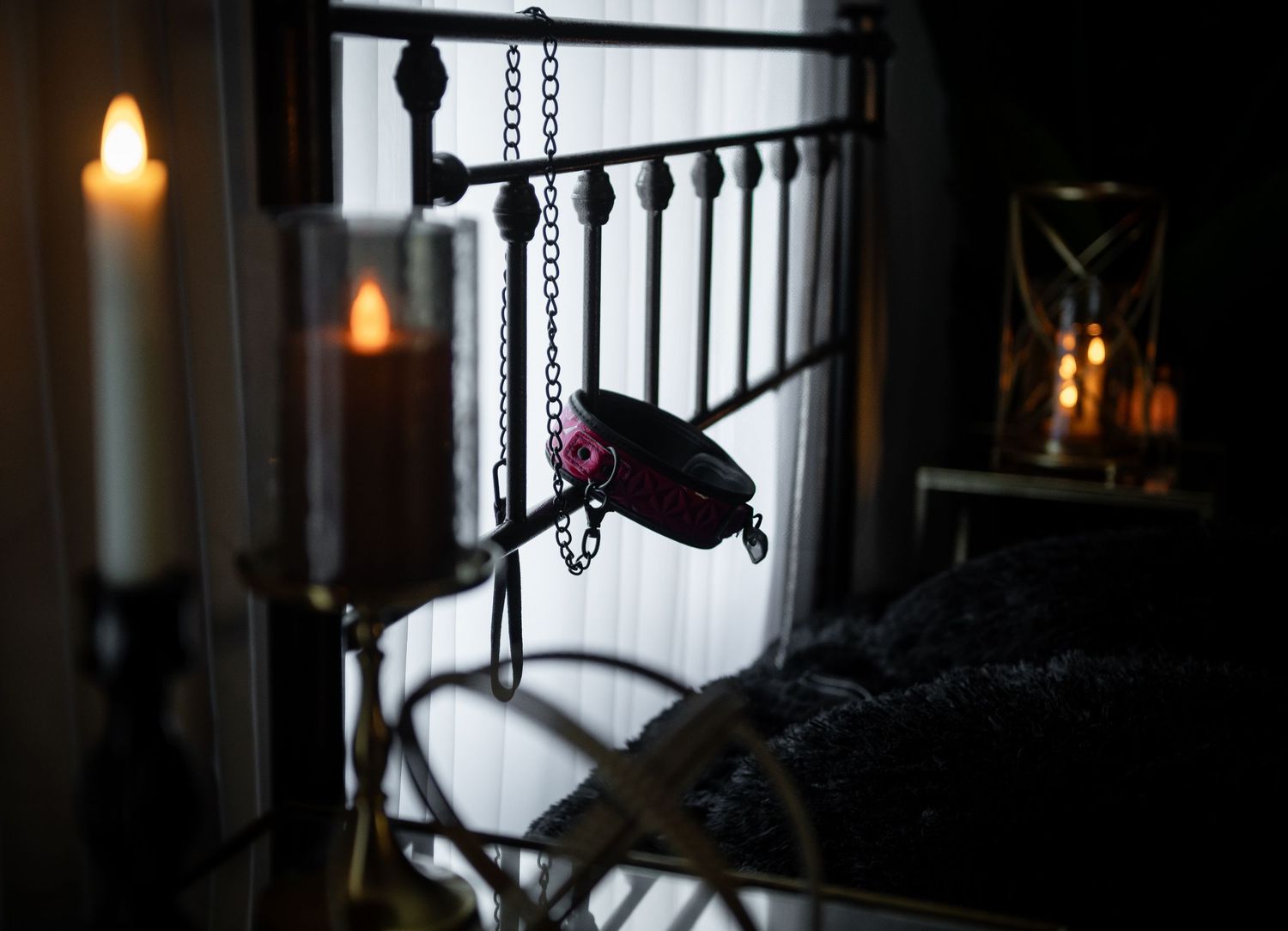 Dark silhouettes of naughty boudoir shoot props create a moody ambiance against a dimly lit interior space.