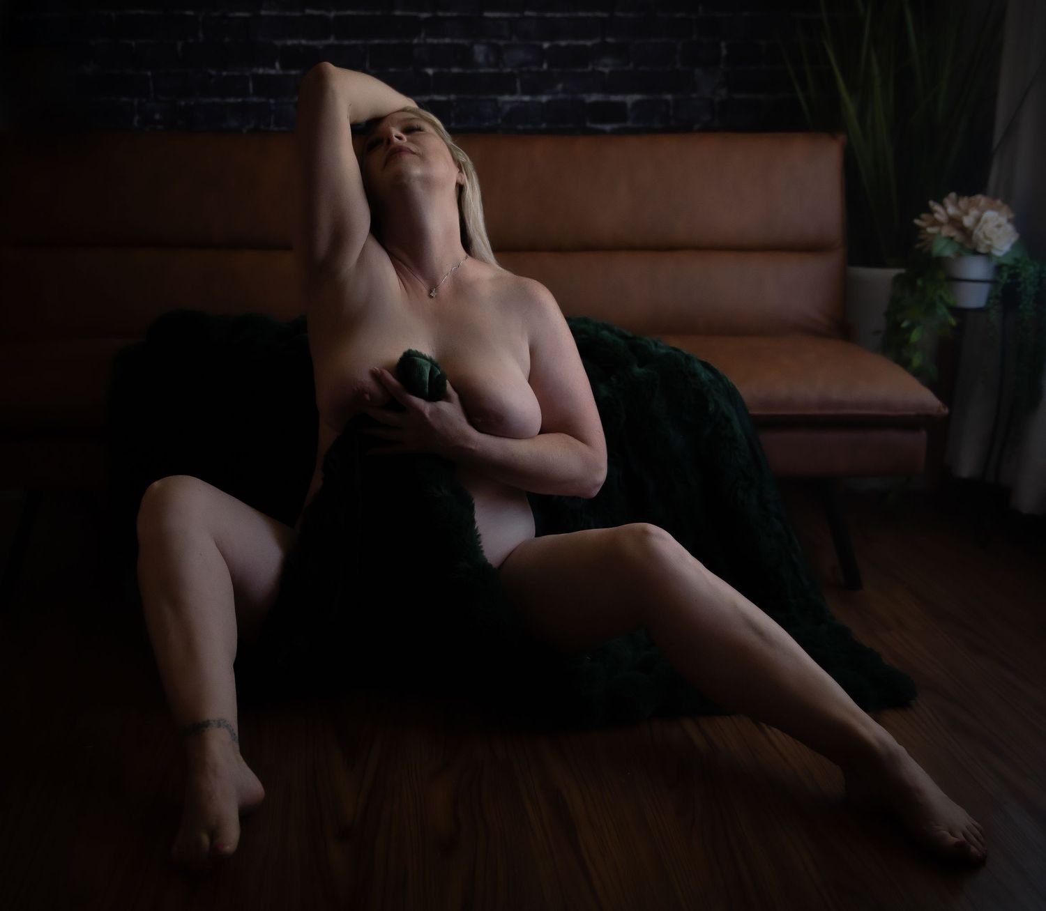 Confidence-boosting photoshoot pose using fur blanket with focus on artistic use of arms and legs.