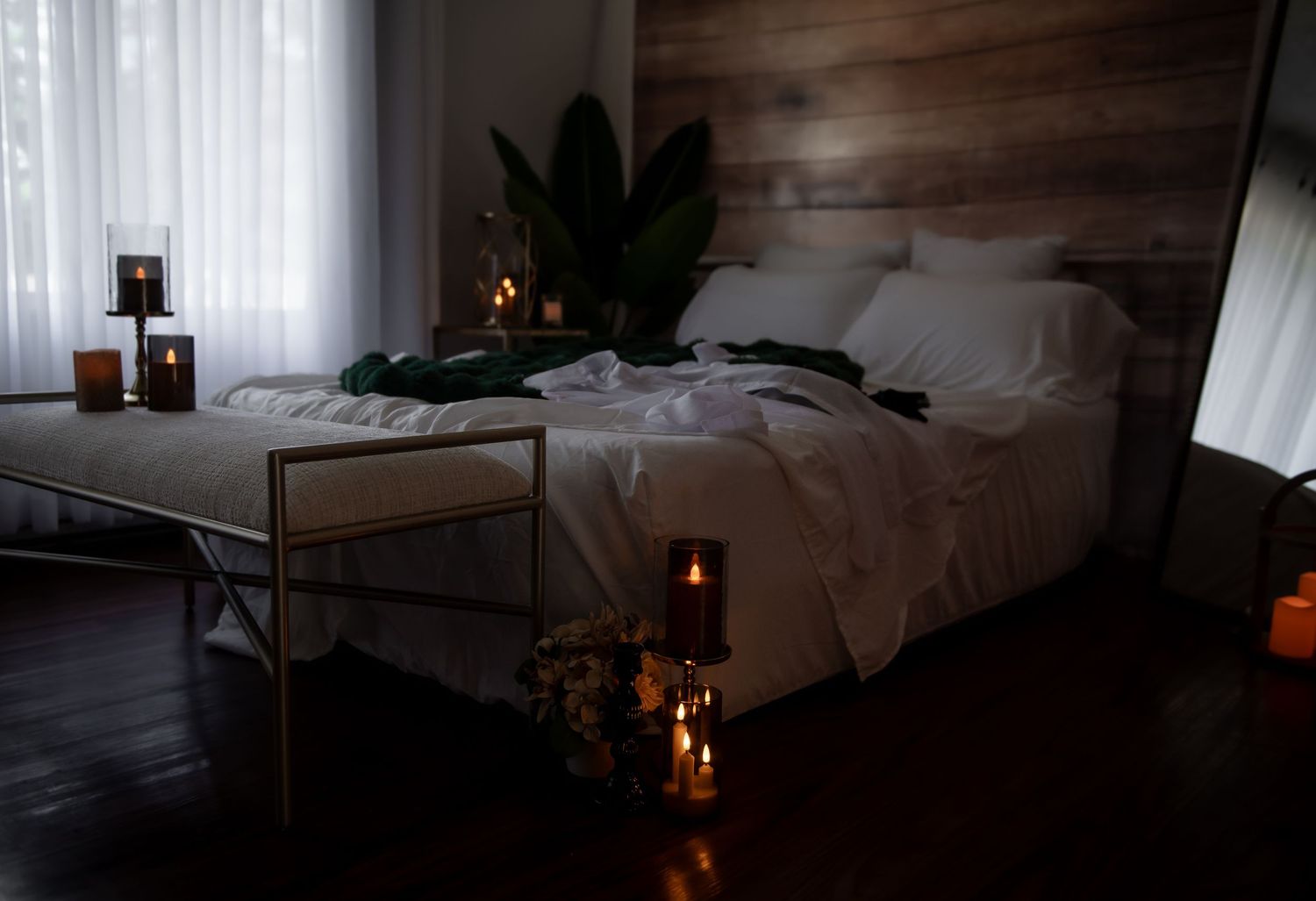 Candlelit area with button down shirt and lingerie creates a cozy and romantic atmosphere in a dark boudoir bedroom setting.