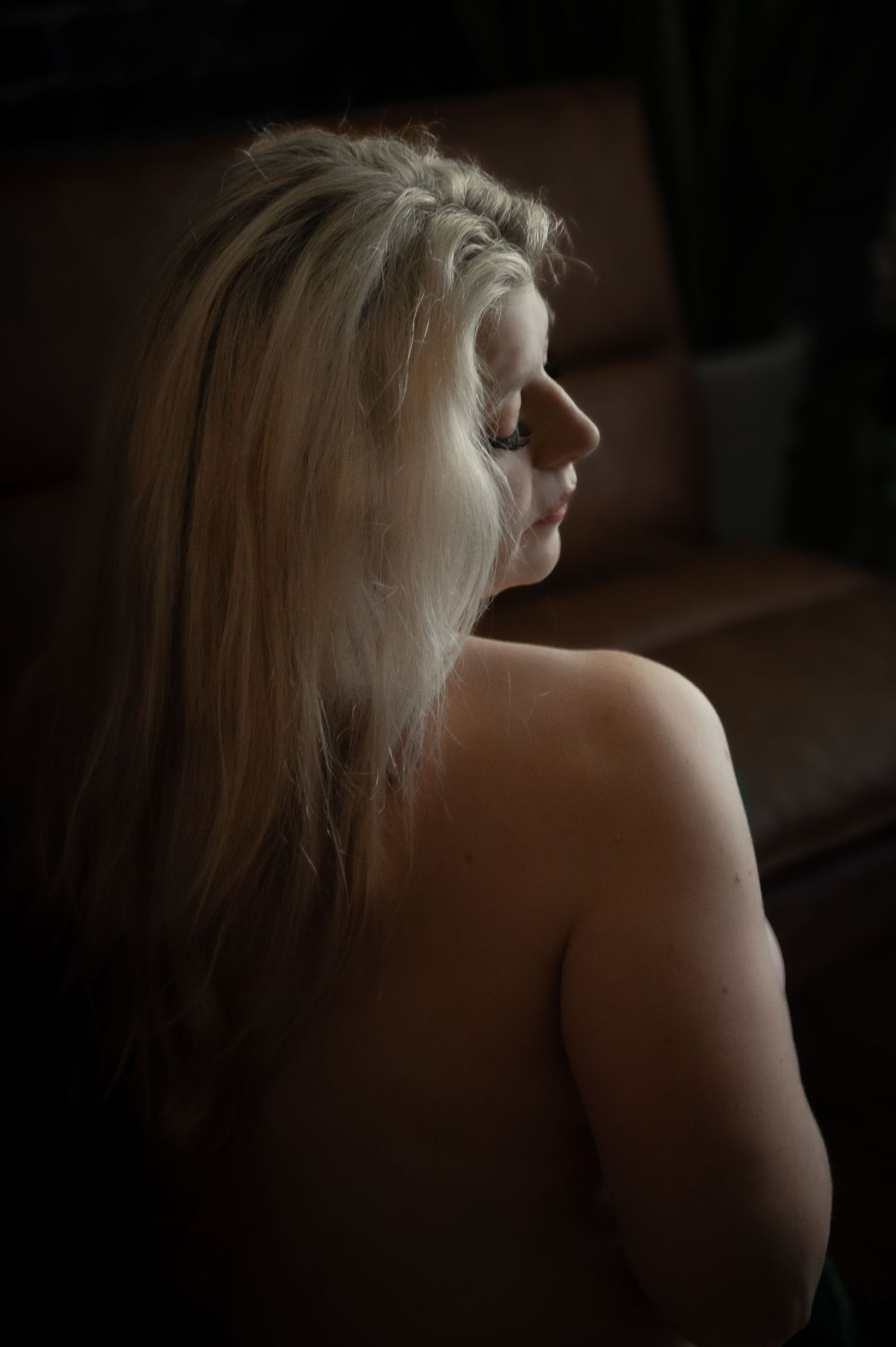 Artistic back view portrait series showing platinum blonde hair against dark background in moody lighting.
