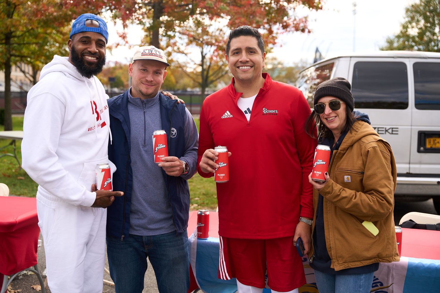 Friends gathered outdoors during autumn enjoying beverages and social time together.