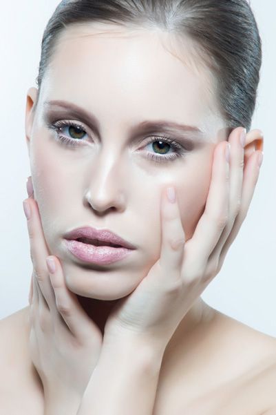 Beauty portrait series showing artistic close-up makeup with pearl accents and soft lighting on bare shoulders.