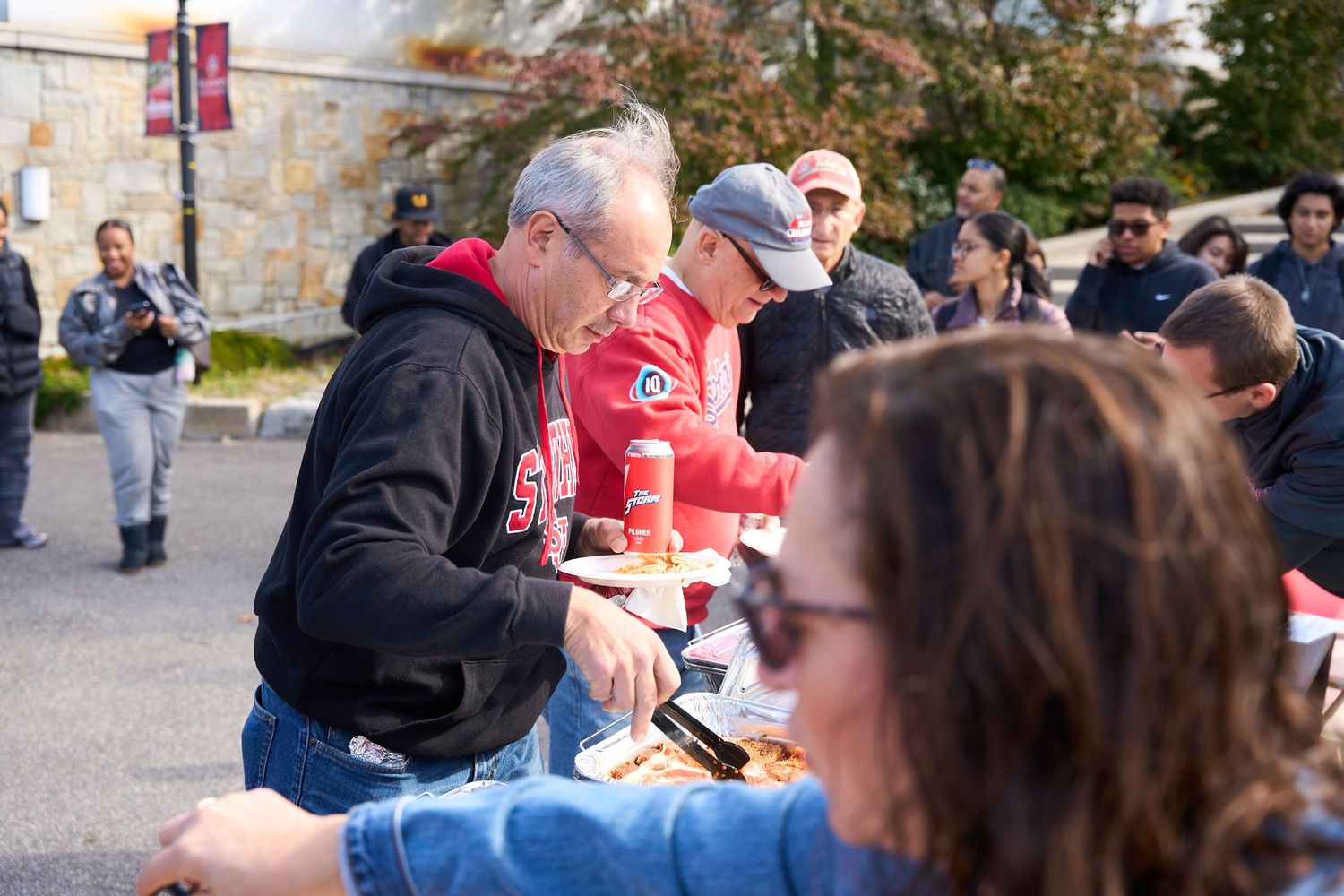 Outdoor gathering with people seated at tables during a daytime event.
