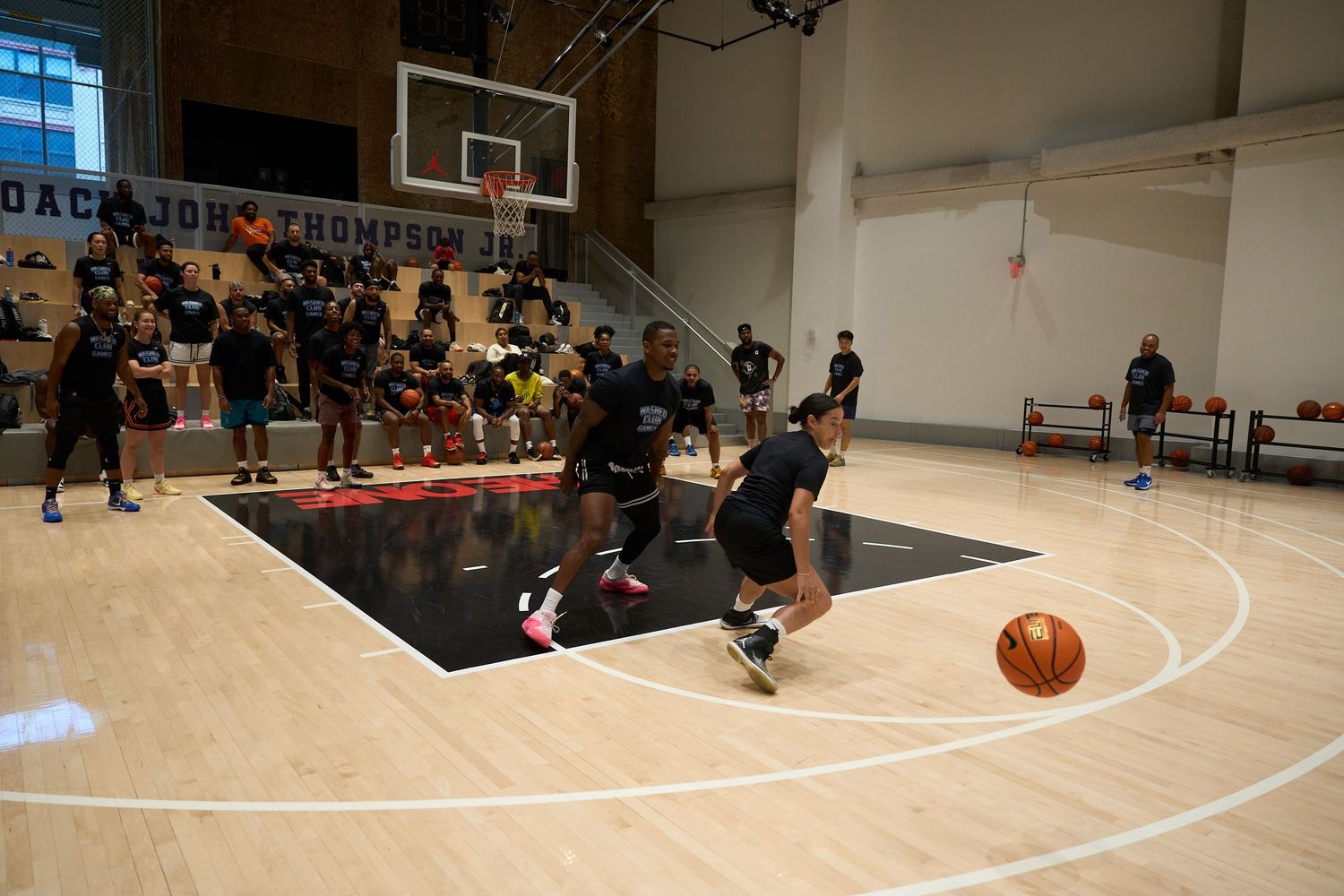 Motion blurred basketball players compete on an indoor court during an intense game.