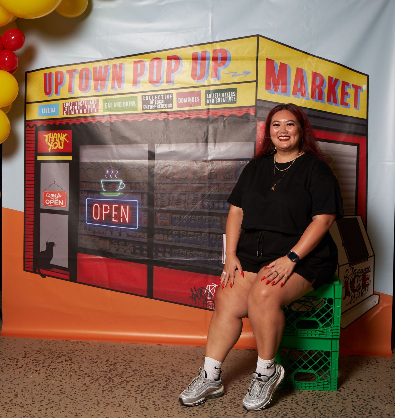 Four connected views of someone seated outside an old-style market storefront with red trim and colorful signage.