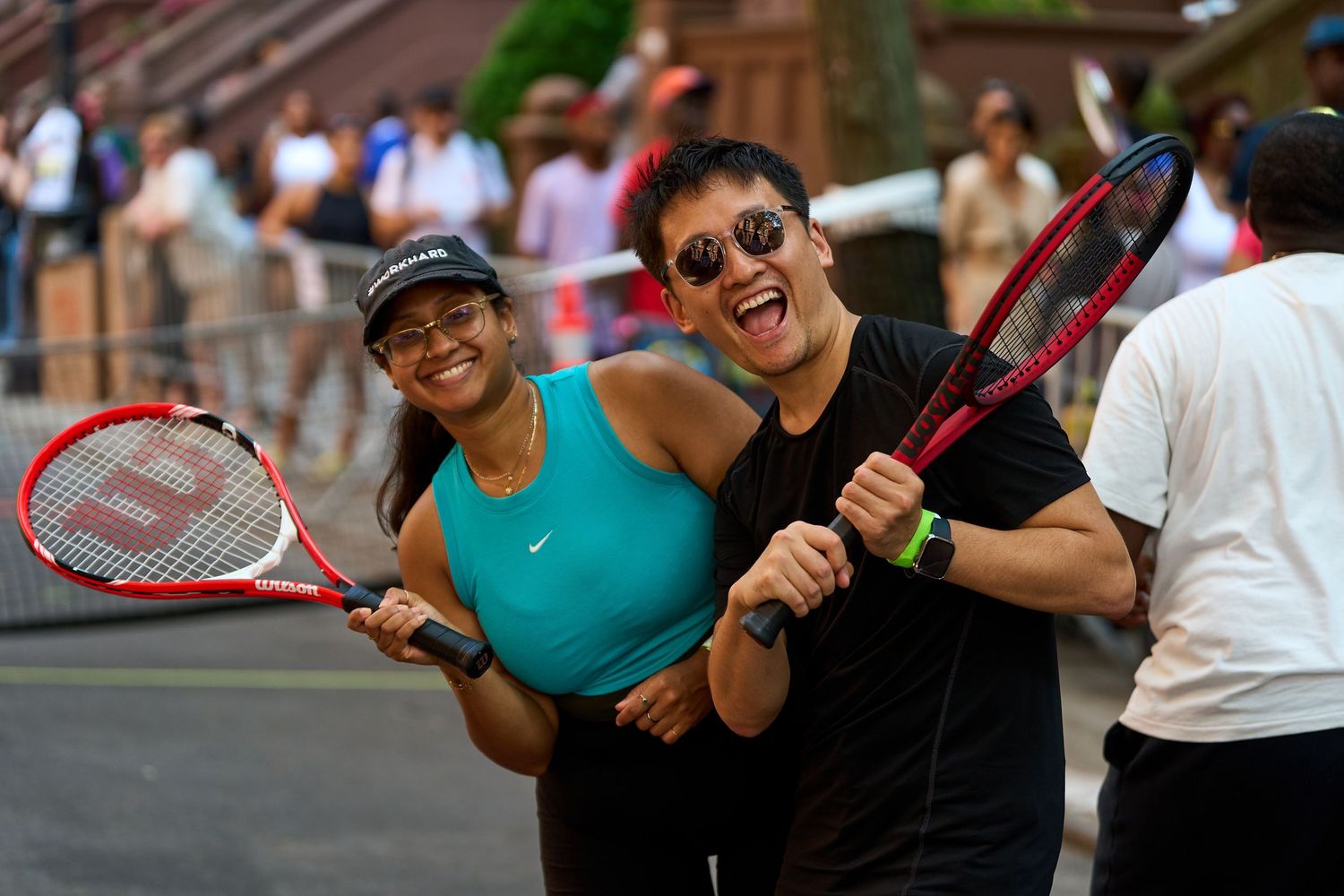 Group playing tennis and engaging in recreational activities on a city street.