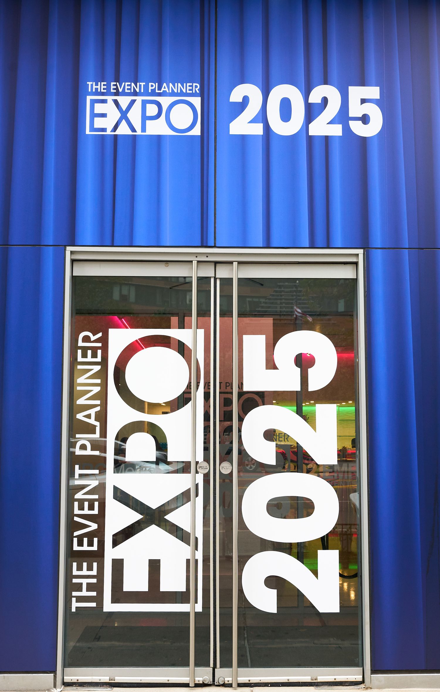 The Event Planner Expo 2025 entrance with large blue signage and glass doors displaying EXPO 2025 branding.