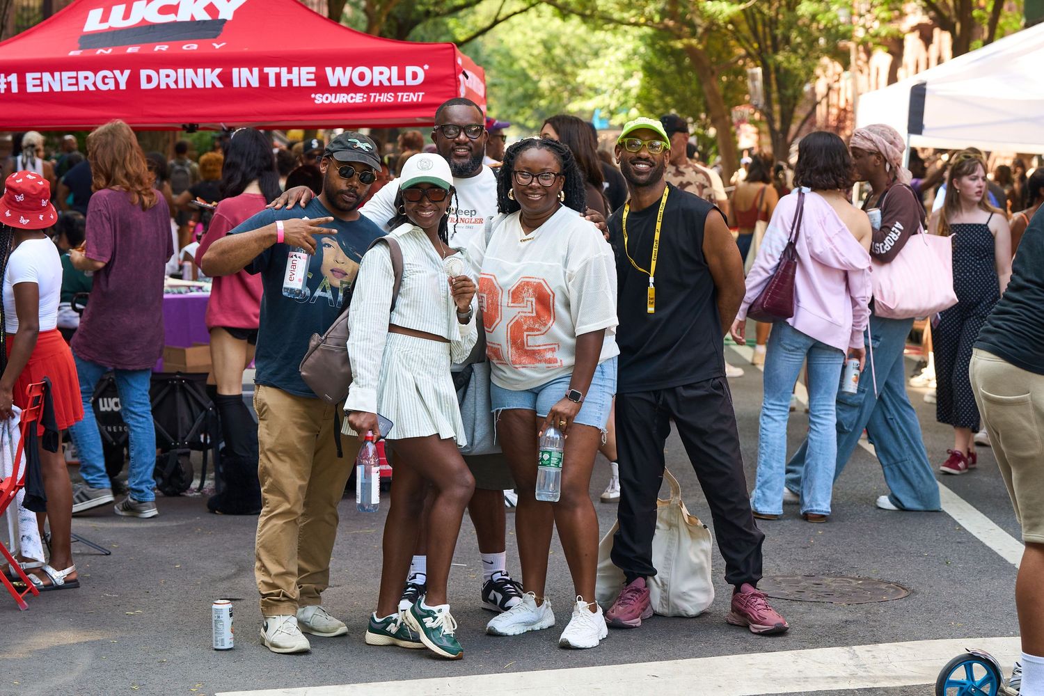 Crowd gathering at an outdoor street festival with tents and vendors.