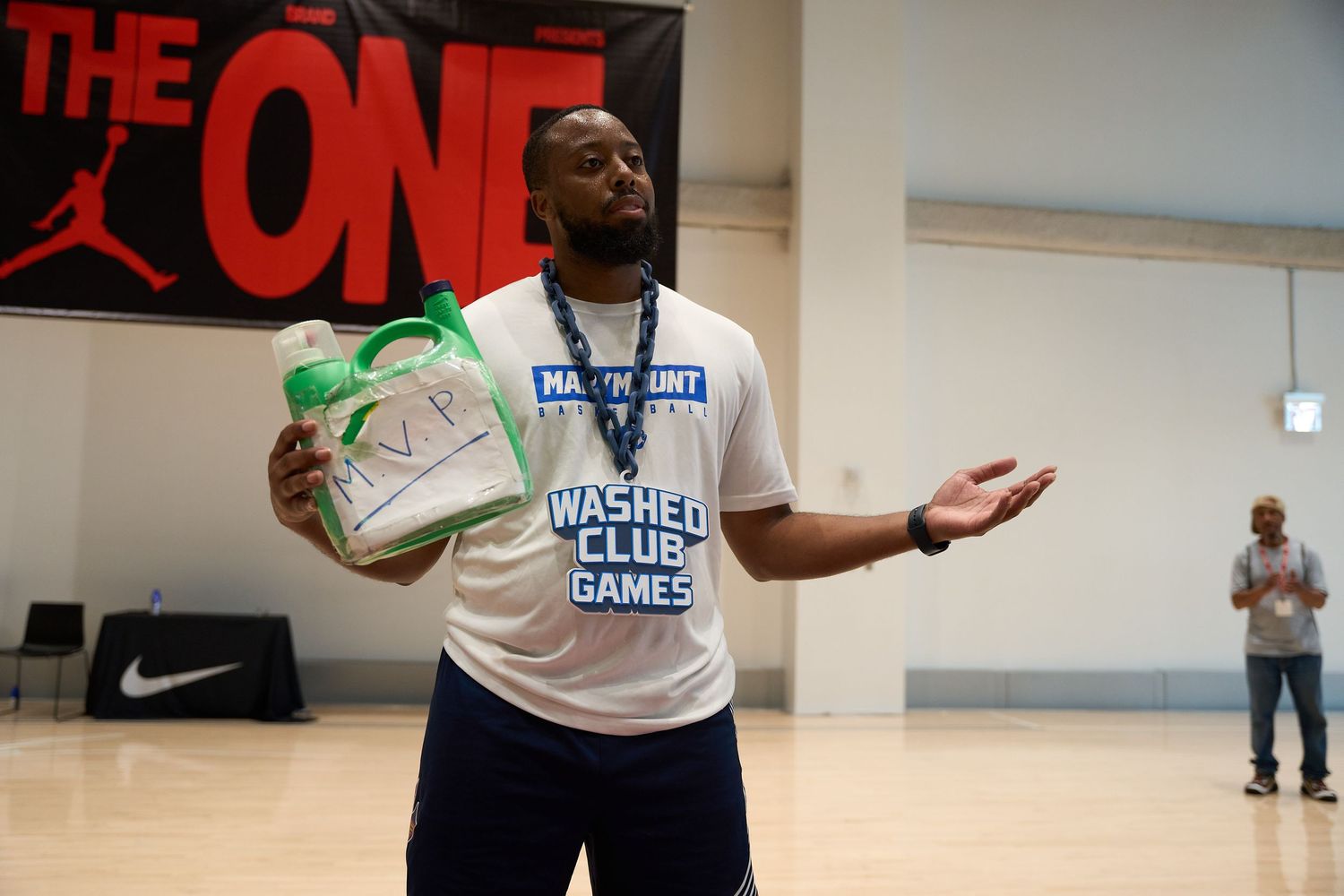 Basketball player in Nike apparel practices stance and hand positioning during indoor training session.
