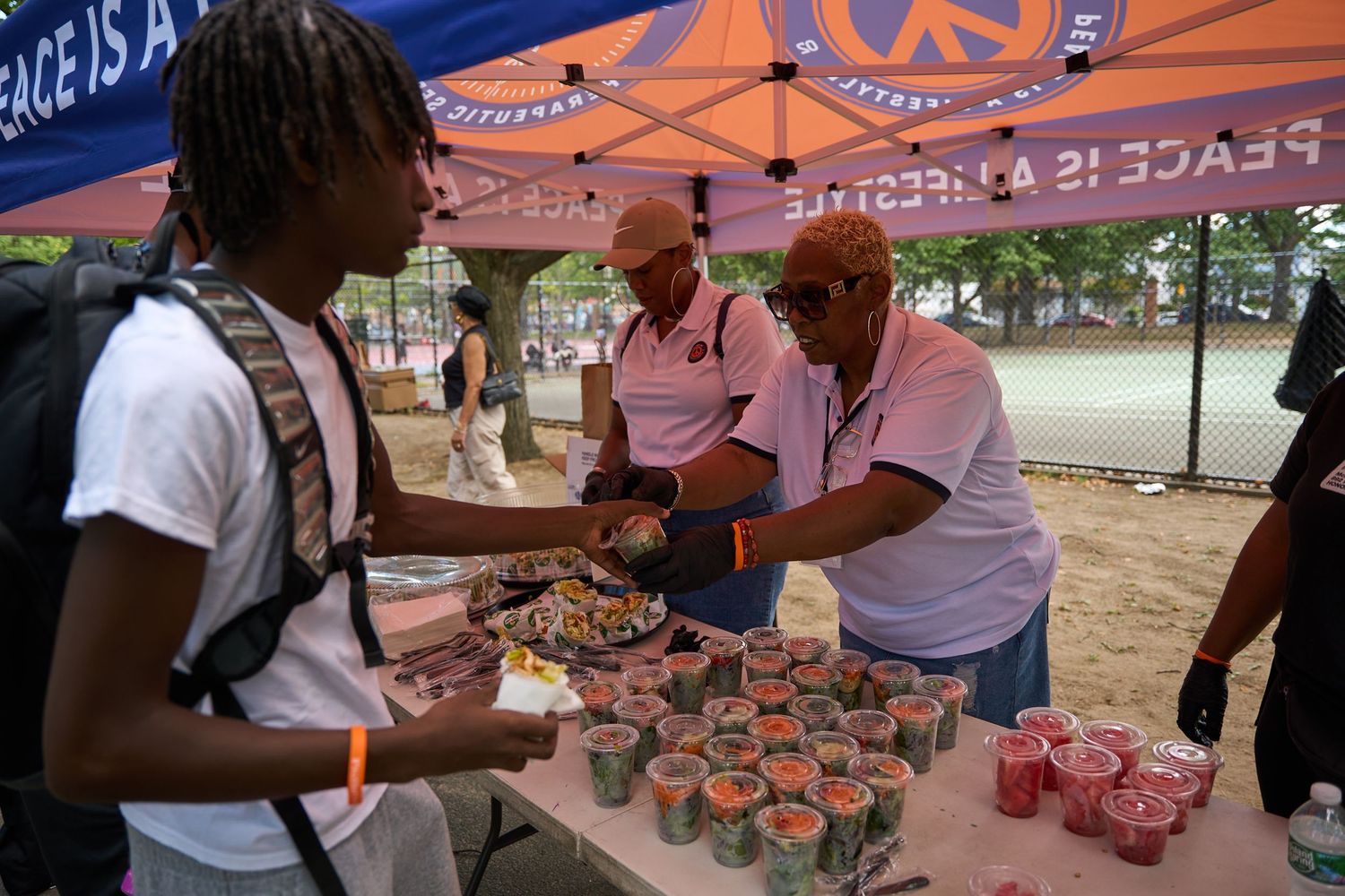 Outdoor event with orange tents and tables displaying food or merchandise at a community gathering.