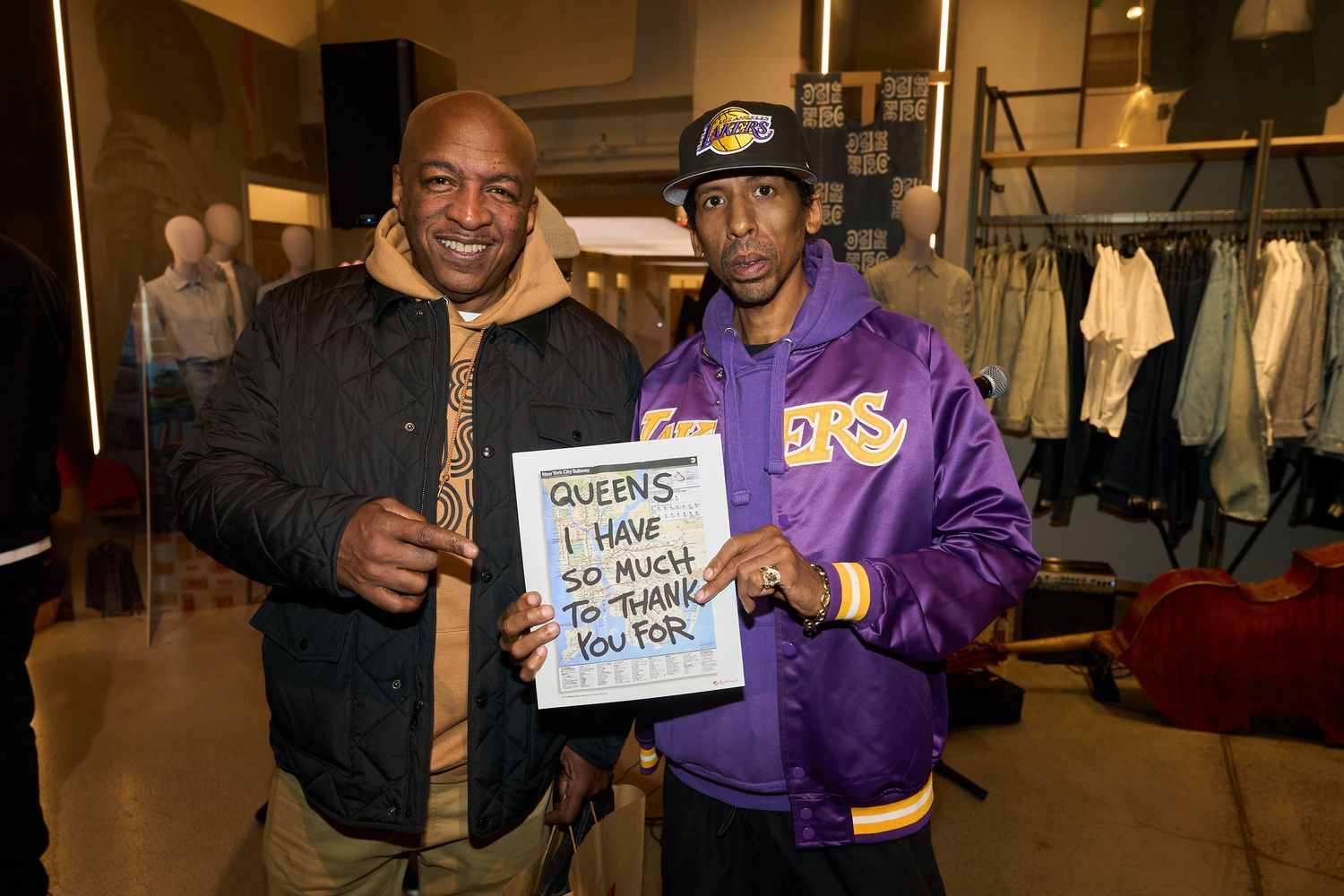 Fans gather at a sports event wearing Lakers jerseys and merchandise while posing for photos.