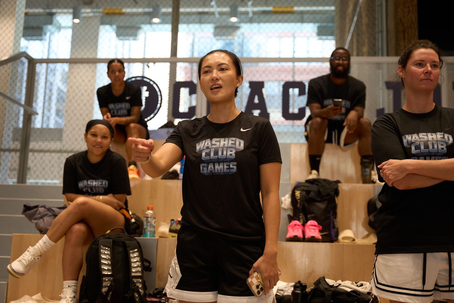 A group wearing black shirts sits around tables in what appears to be a training or workshop setting.
