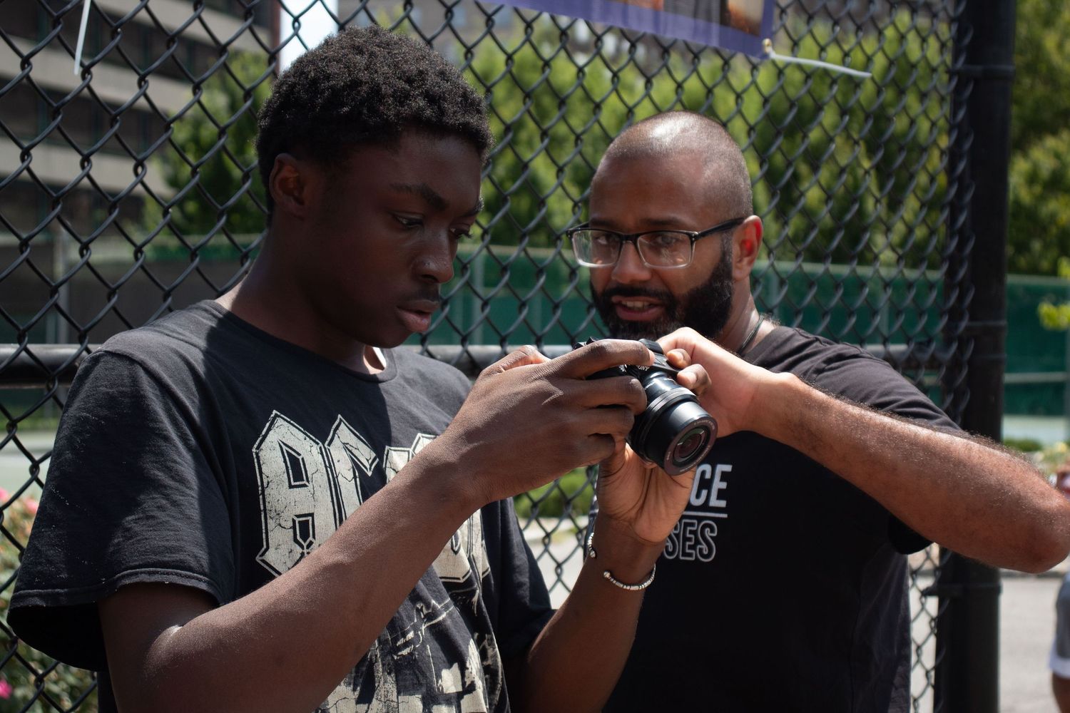 Four sequential photos show someone taking a bite of food while standing near a chain link fence.