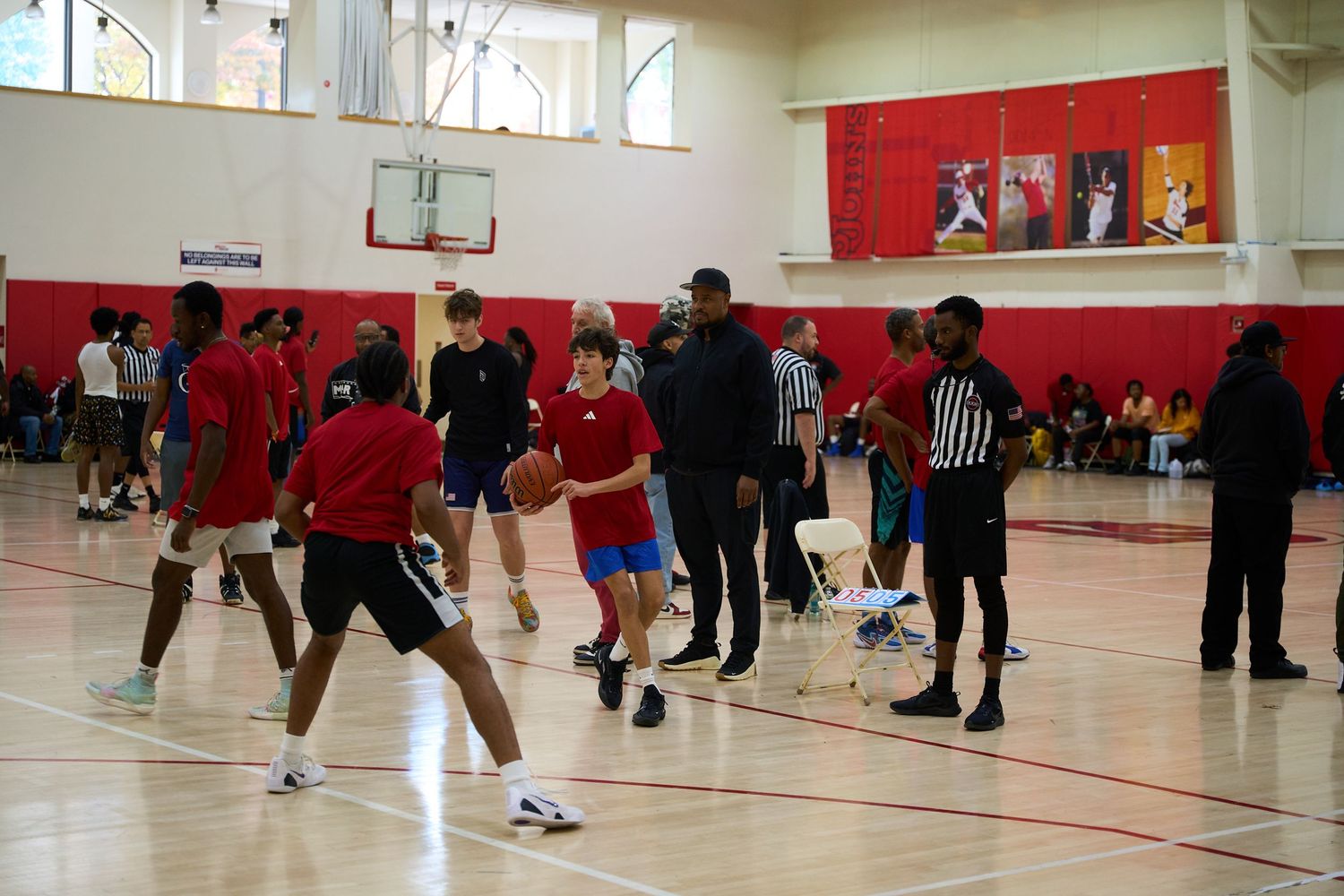 Basketball players spread across a gymnasium court during what appears to be a practice or training session.