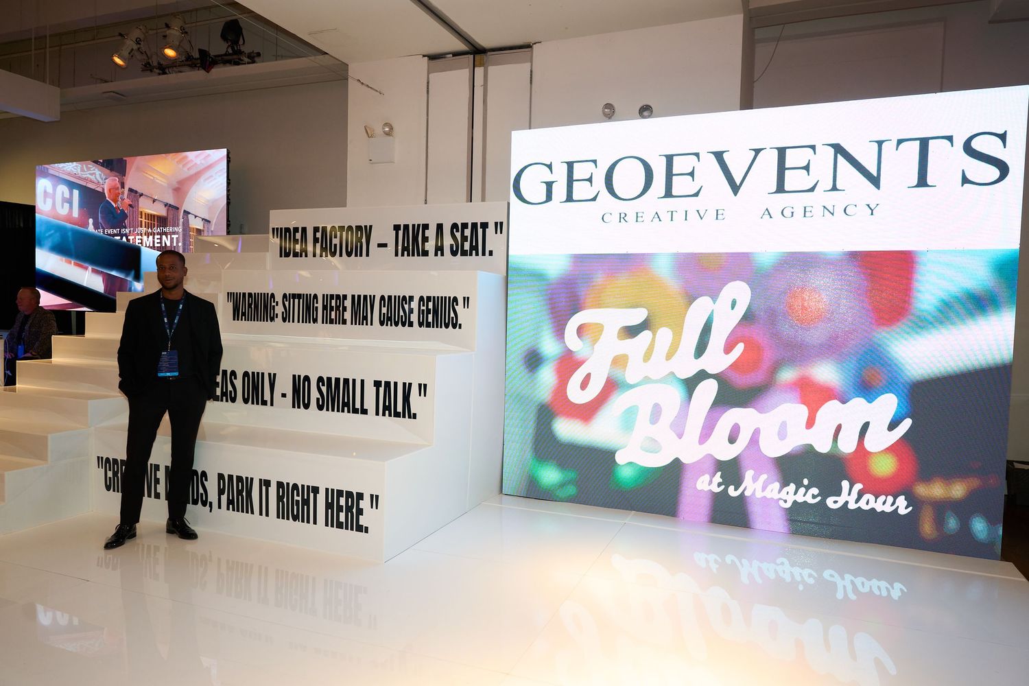 A series of illuminated signs and displays mounted on walls in a dark indoor space.