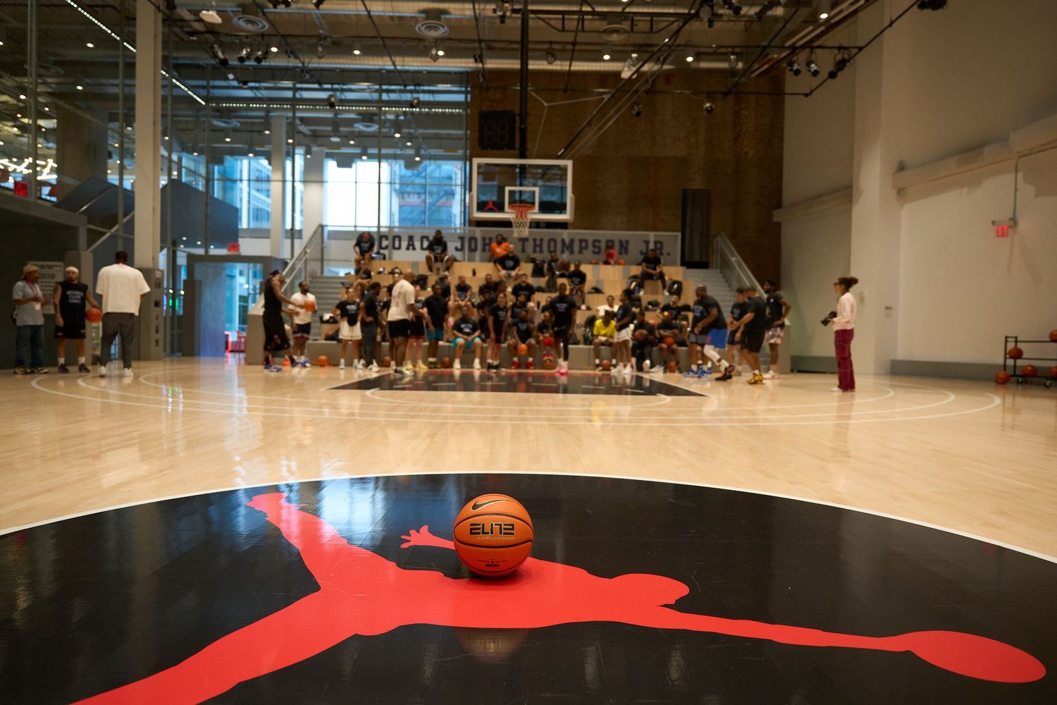 A basketball court with a large red painted area viewed from above with a basketball visible on the floor.