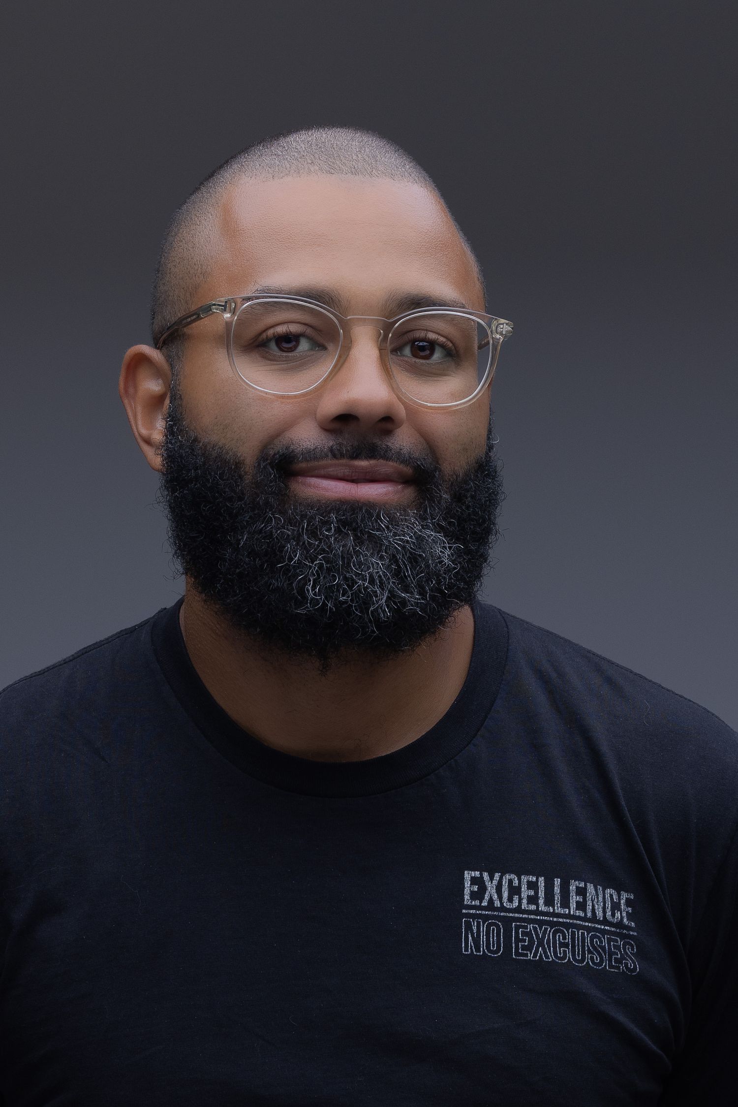 Close-up portrait series showing different angles of a man with glasses wearing a black t-shirt and full beard against gray background.