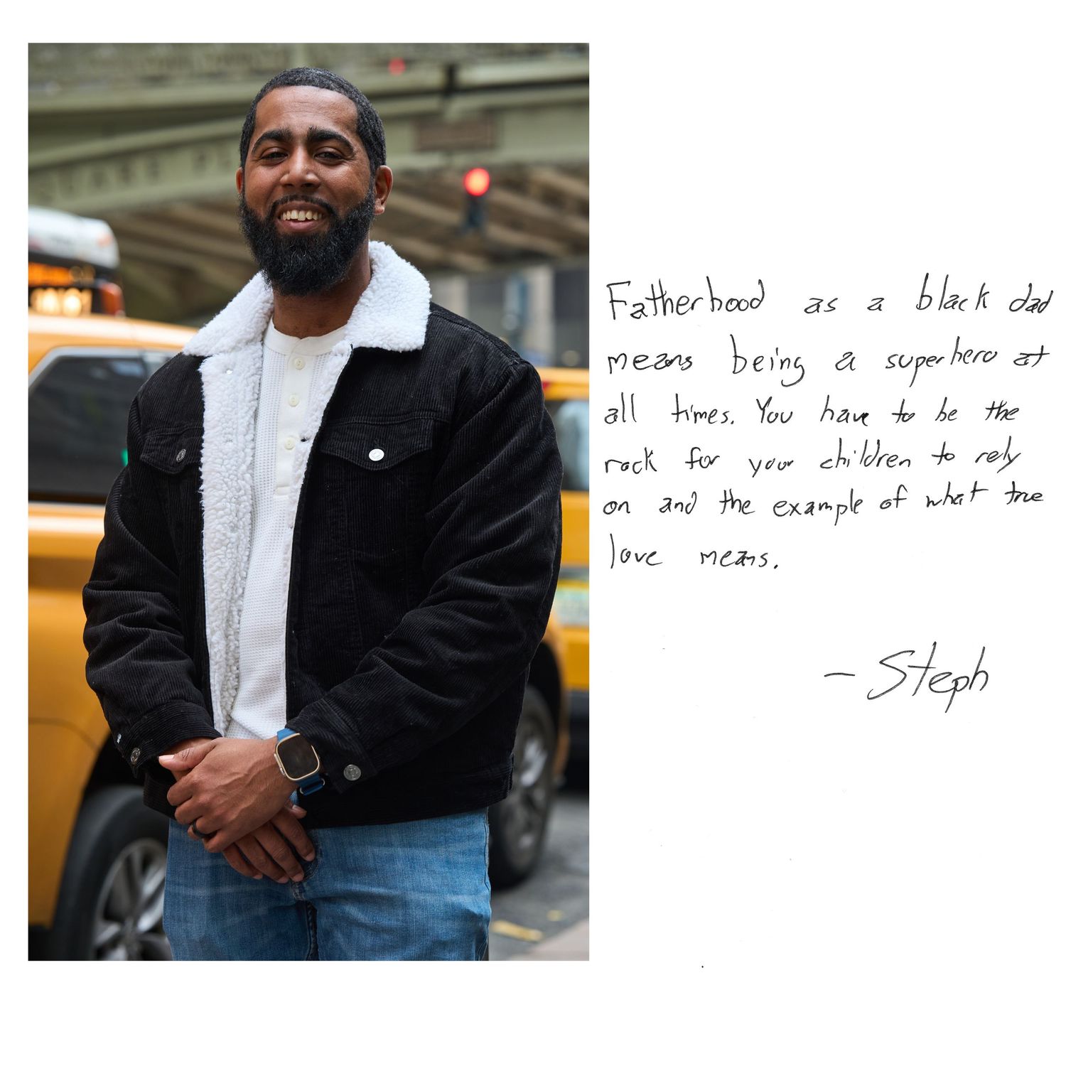 Someone in a black winter jacket and jeans stands on a city street next to handwritten text on white paper.