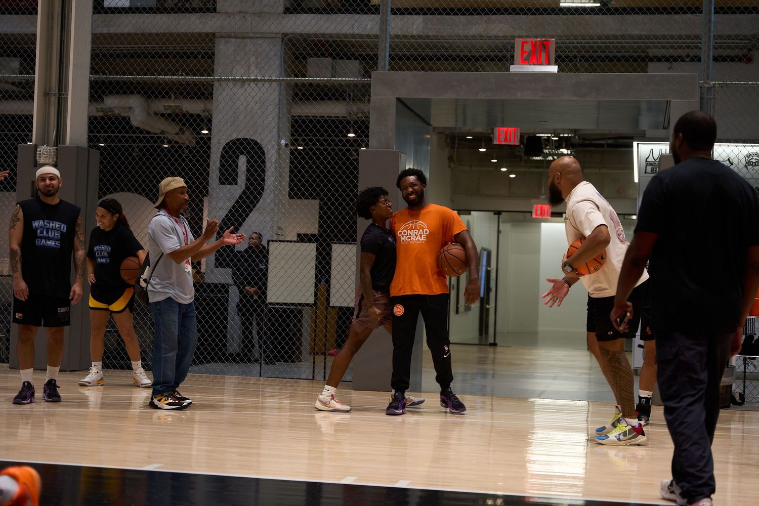 People practicing Latin dance moves together at a dance studio with reflective floors.