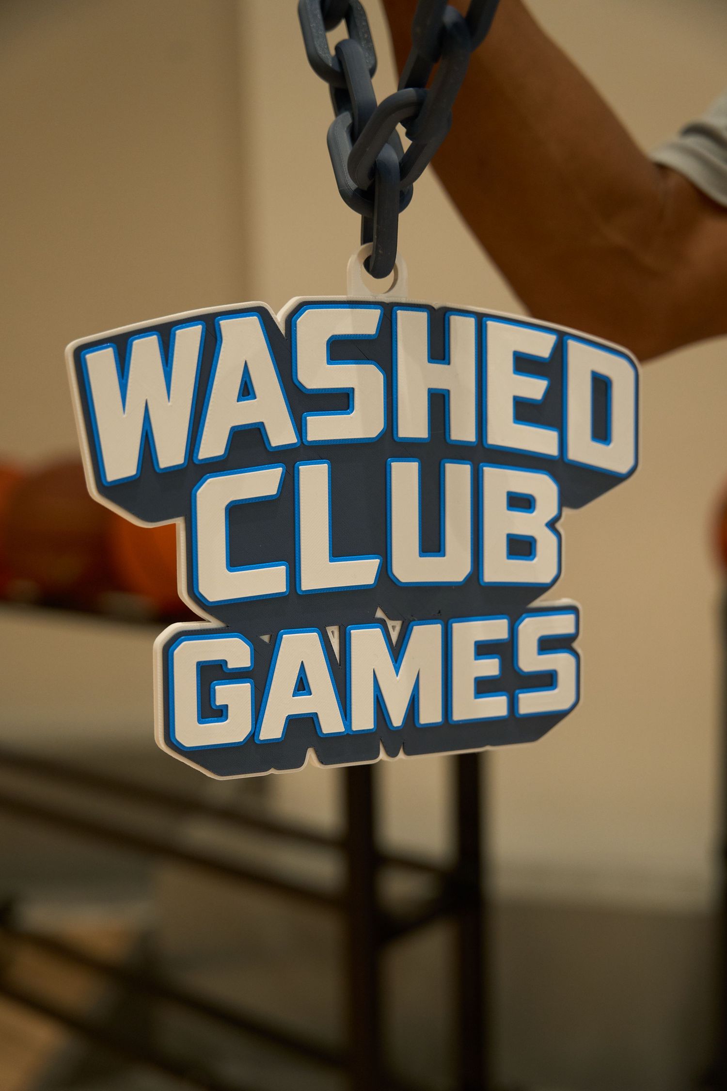 Backlit blue letters spelling out 'WASHED GAMES CLUB' mounted on a wall or surface with illuminated lighting effects.