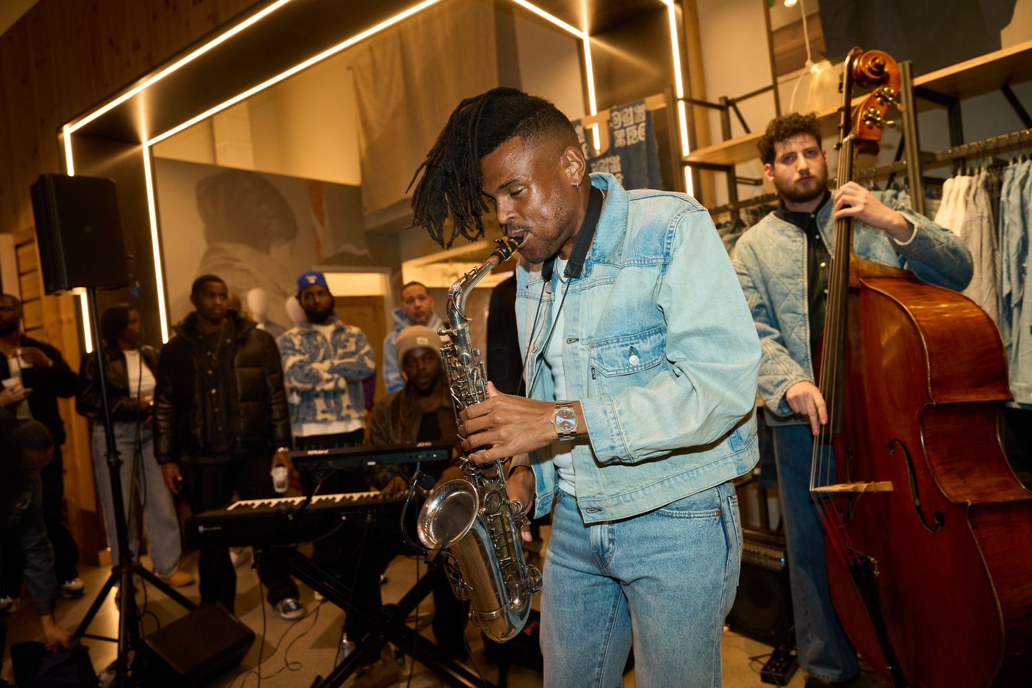 Musicians performing with instruments including a saxophone and double bass in a warmly lit venue.