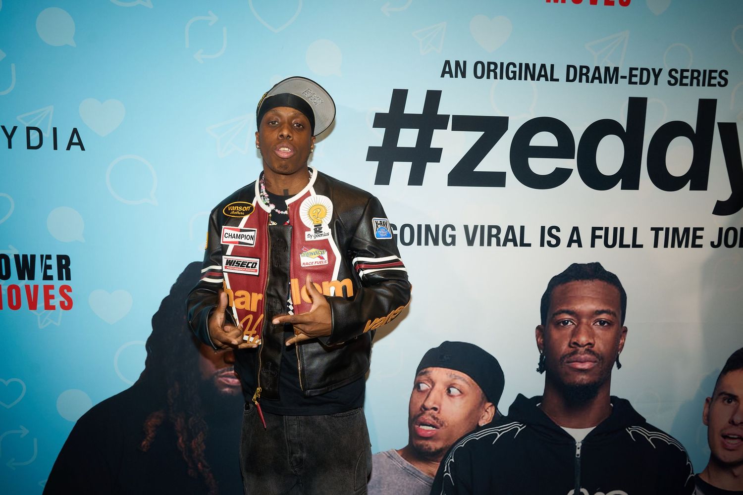 Man posing at #Zeddy original drama-comedy series promotional event backdrop.