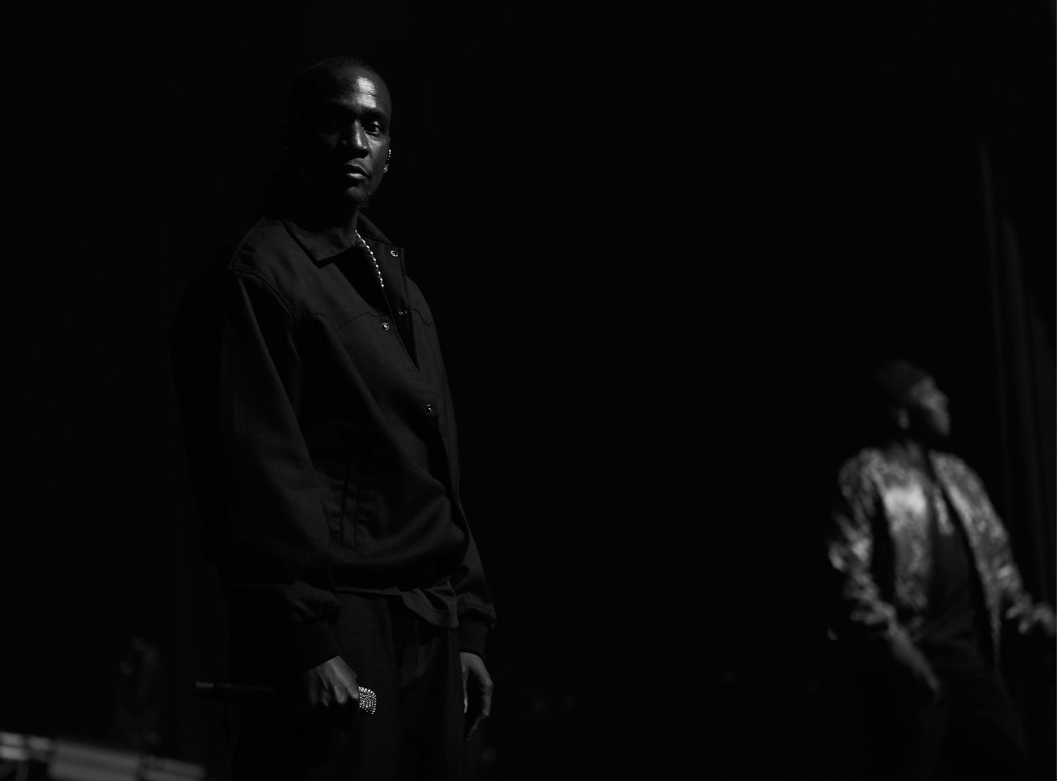 A dramatic black and white photo series showing a figure in shadows against dark backgrounds.