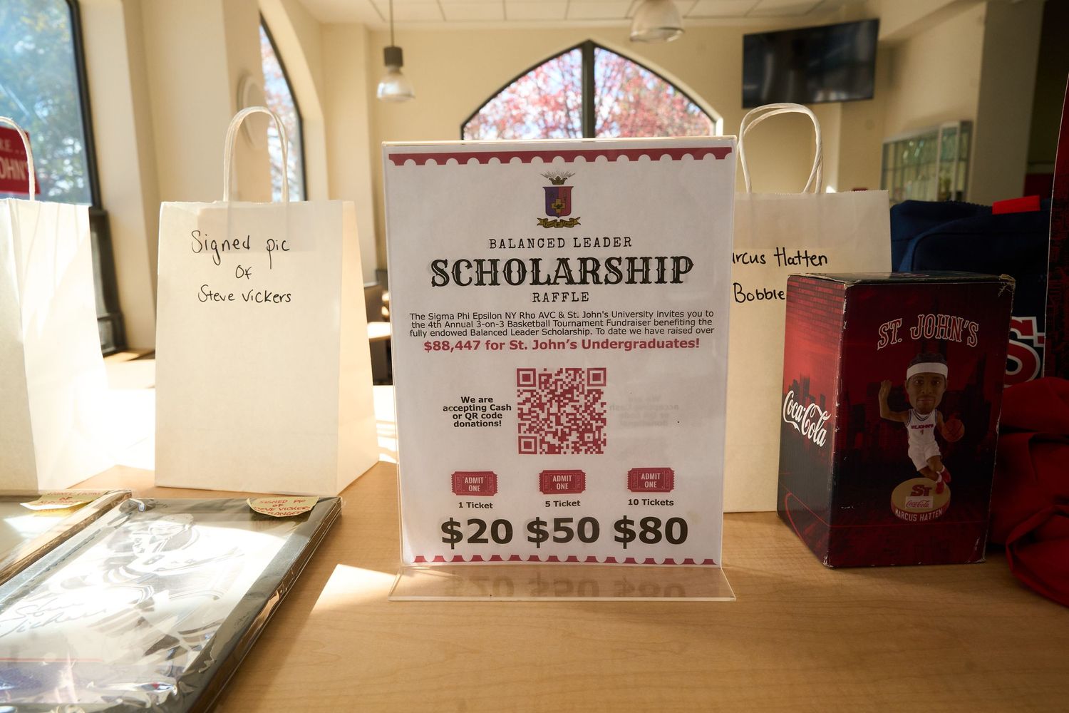 Interior view of a beige-colored hallway with scholarship information signs mounted on the walls.