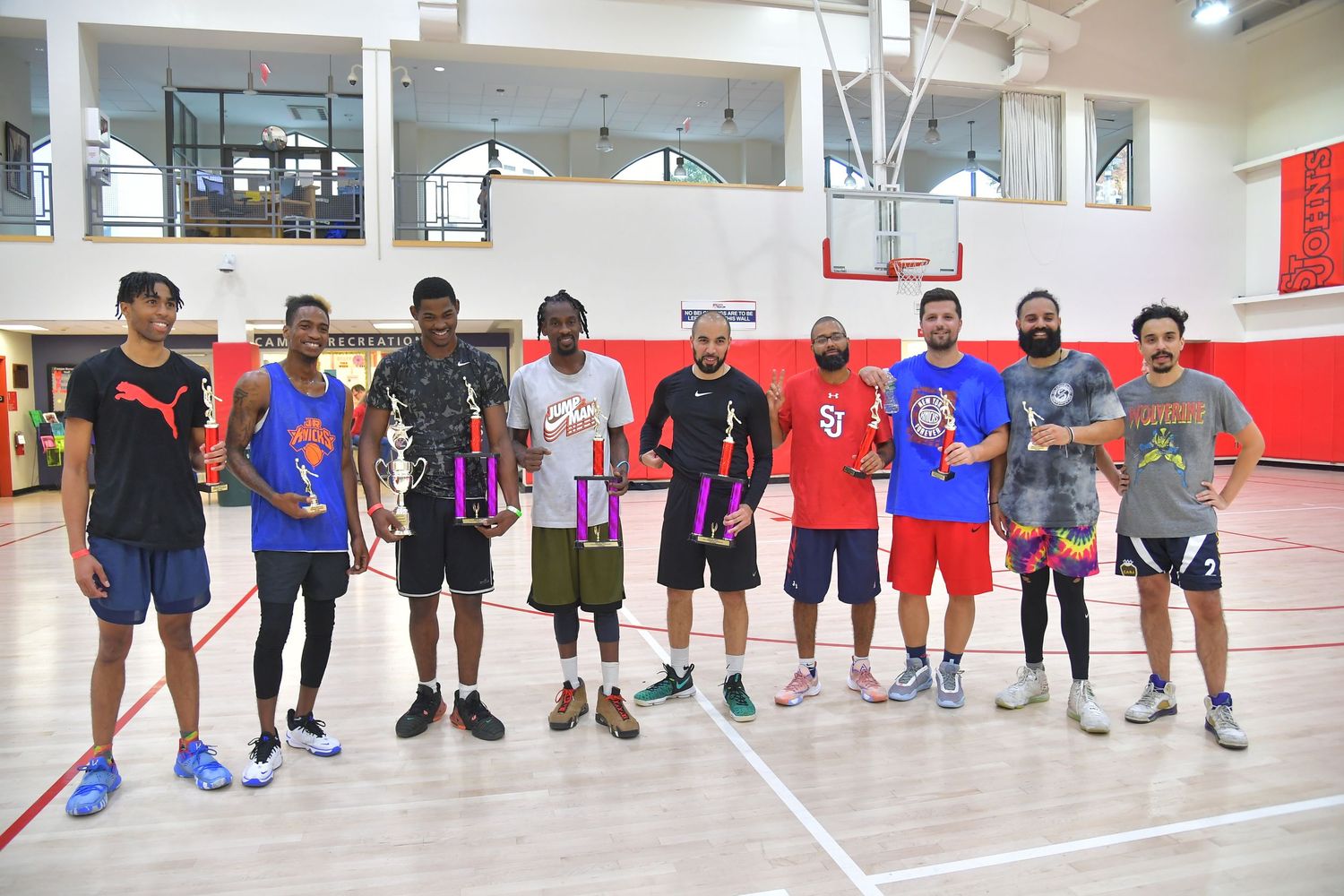 Basketball players line up along the sideline of an indoor court during a training session or practice.