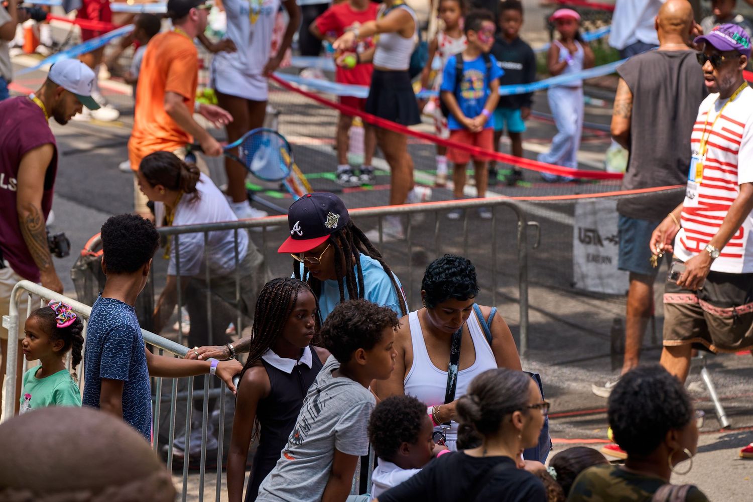Large crowd gathered on a city street participating in an outdoor yoga or fitness class with mats spread out.