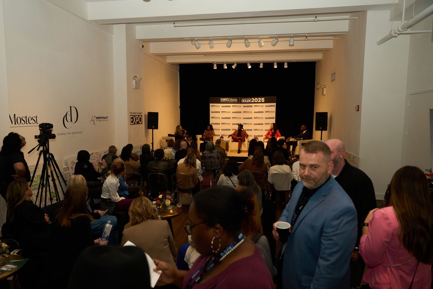 Crowded indoor event space with attendees mingling and networking.