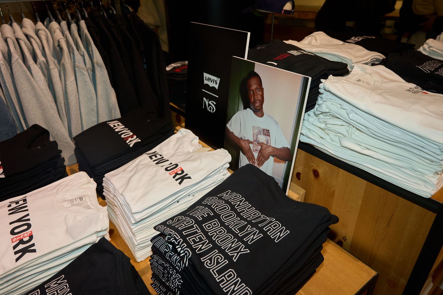 Neatly folded t-shirts in black and white colors displayed in retail store shelves.
