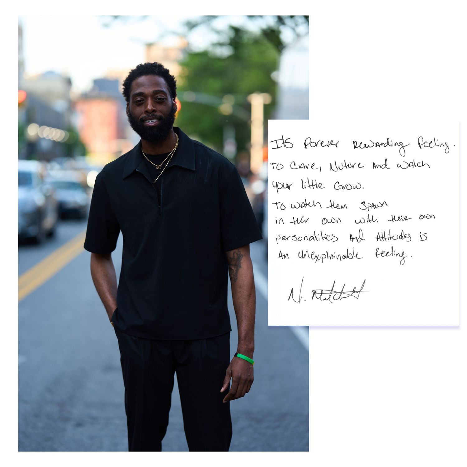 A figure in all black attire poses on a city street while holding up a handwritten note in natural daylight.