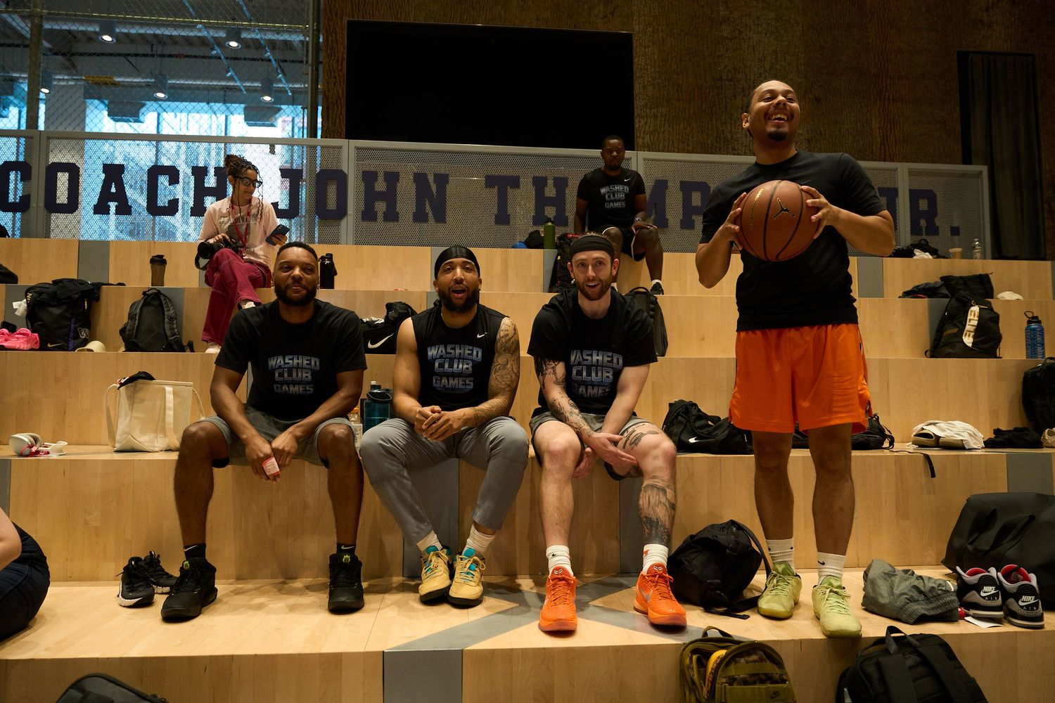 Basketball players rest on a bench in the Coach John Thompson Locker Room during a game break.