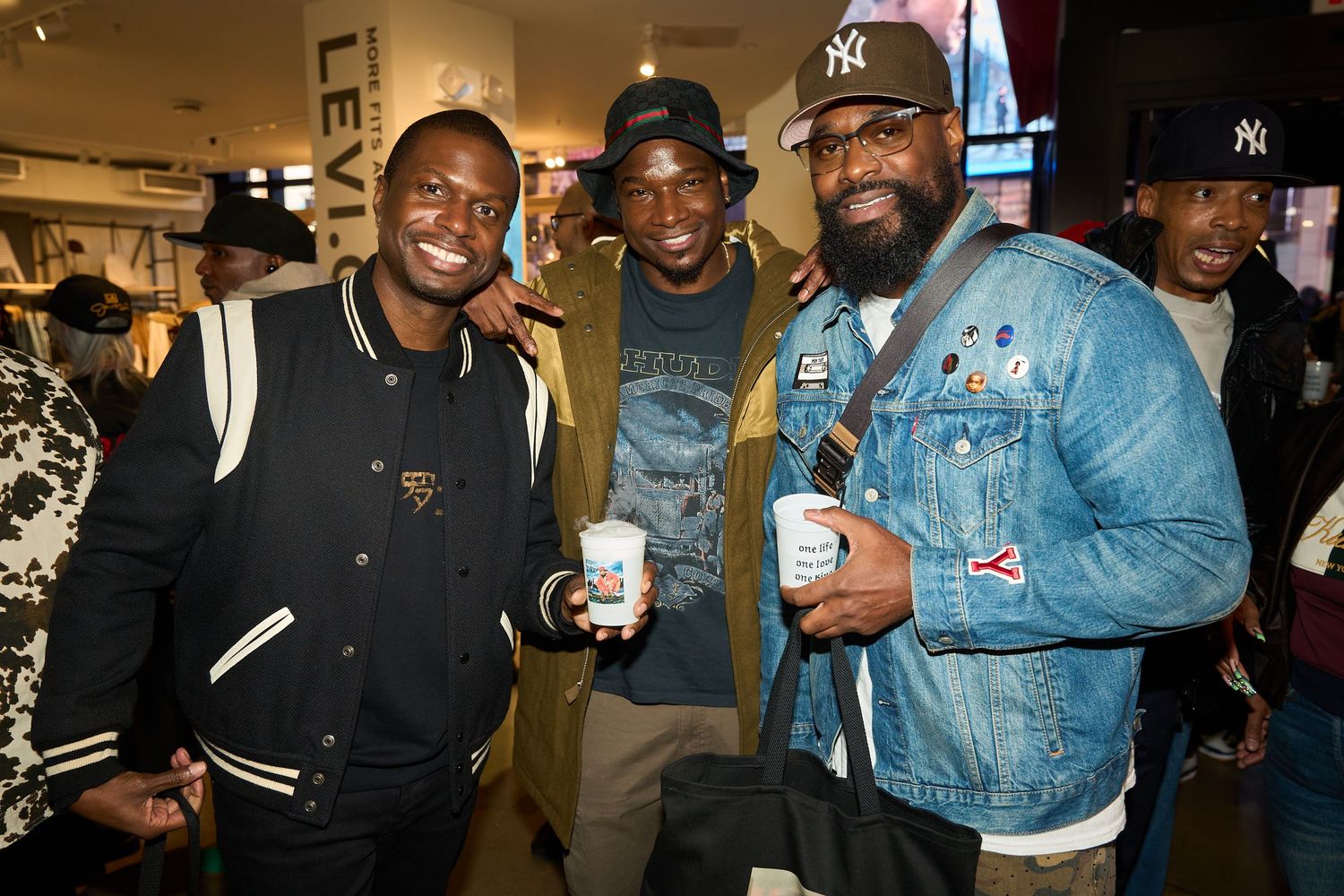A group of people gathered together at an indoor event, smiling and socializing in a casual setting.