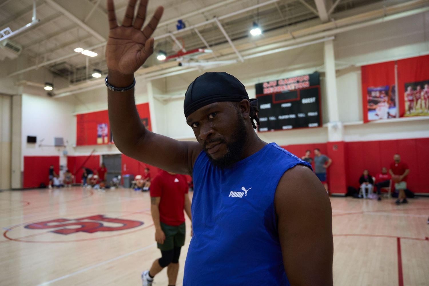 Athletes practicing basketball moves and drills in a well-lit indoor gymnasium.