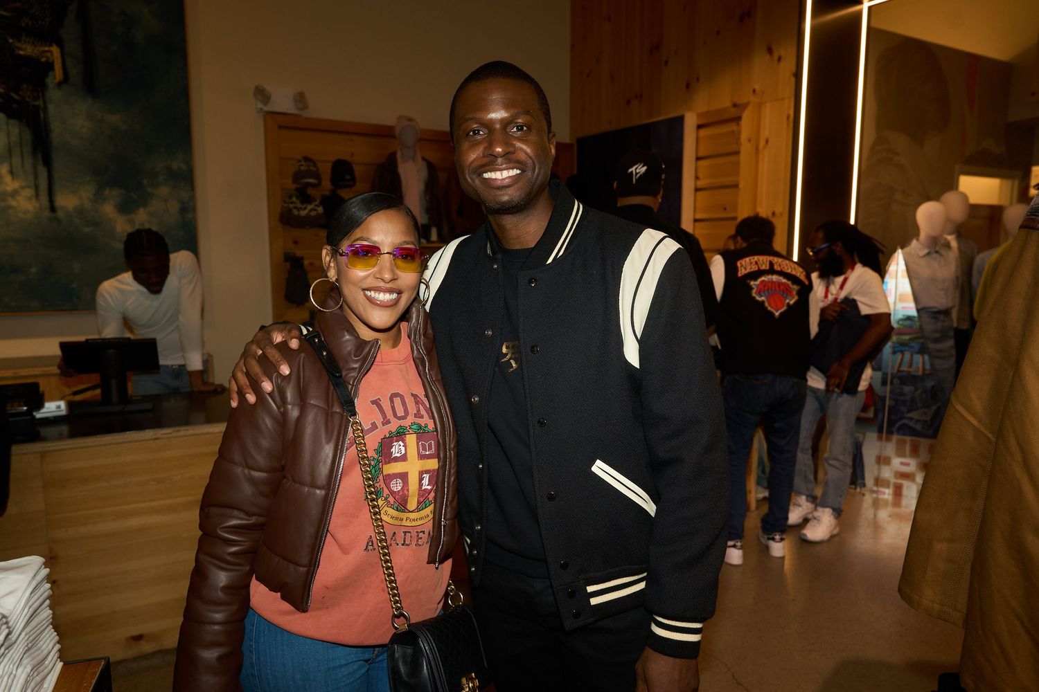 People gathered at an indoor event space wearing casual attire and smiling for photos.