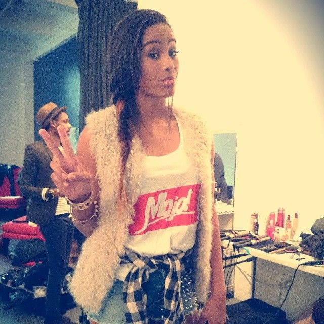 A woman in a furry white jacket poses expressively in a series of candid shots indoors.