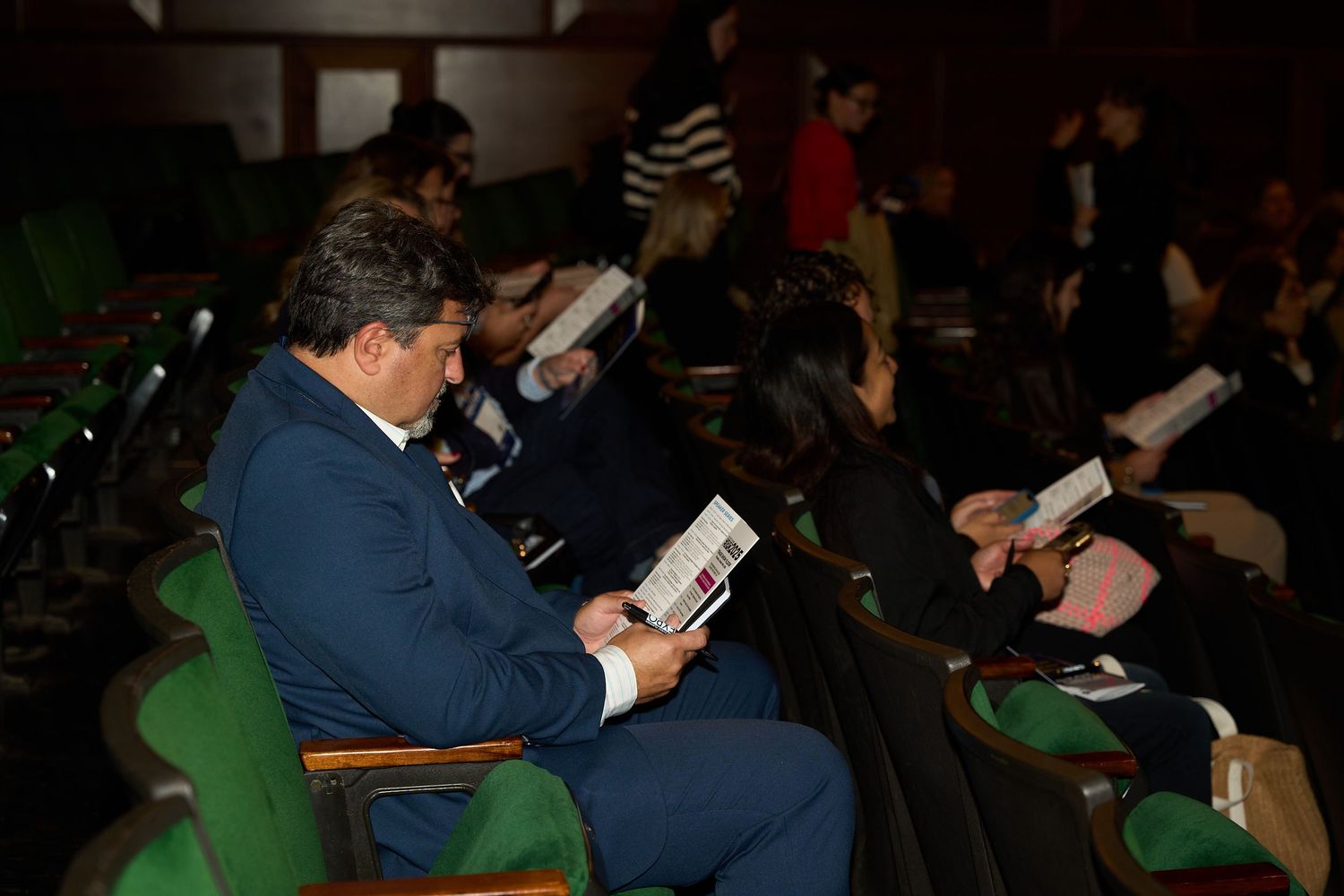 A crowd of people seated in an auditorium during a presentation or performance.