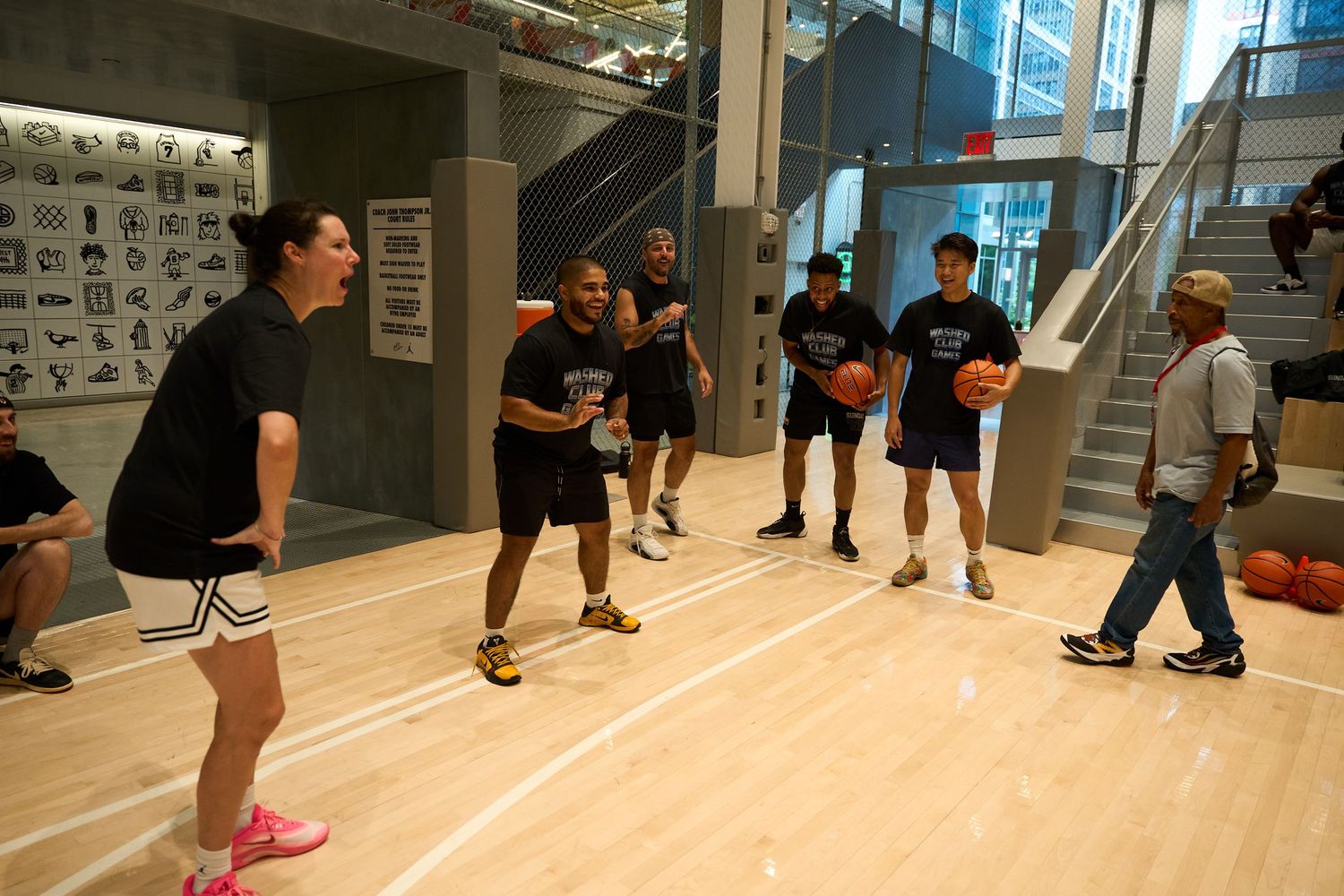 Students practice dance moves in a bright studio with mirrored walls during a group dance class.