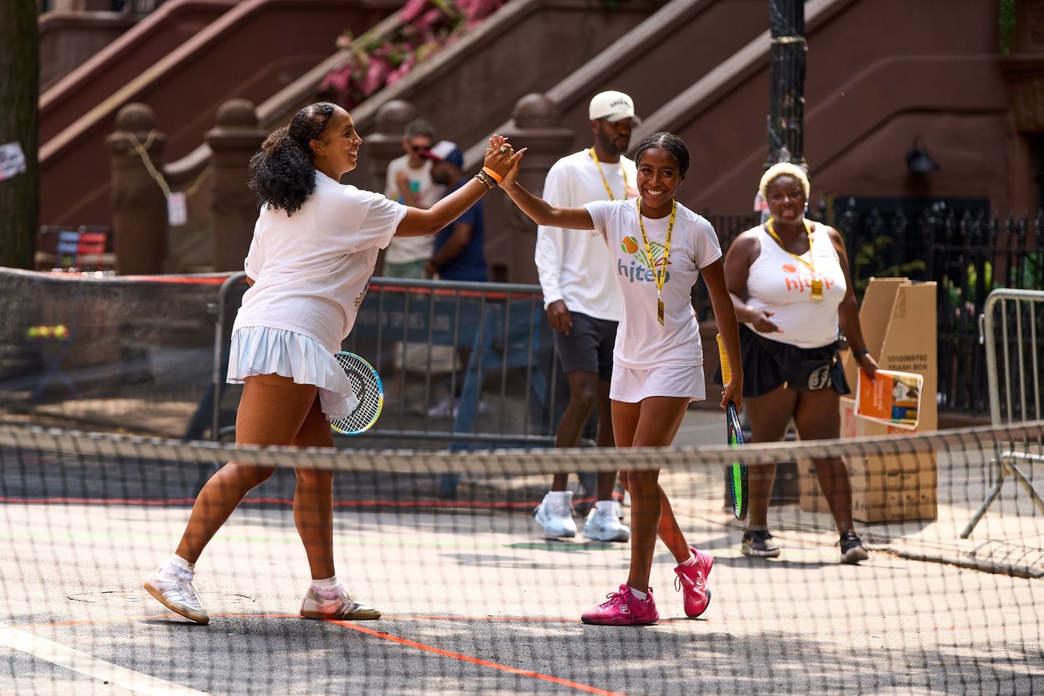 A group of people playing pickleball on outdoor courts during a sunny day.