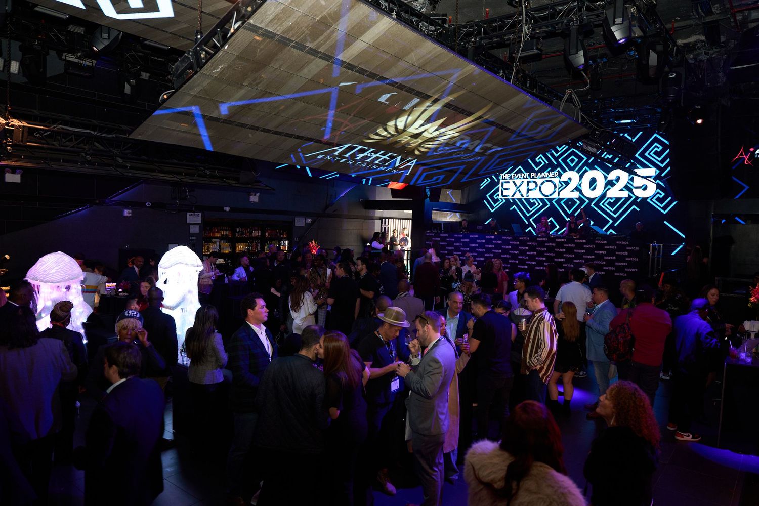 Large nightclub venue with blue LED lighting and crowd silhouettes visible against illuminated ceiling.