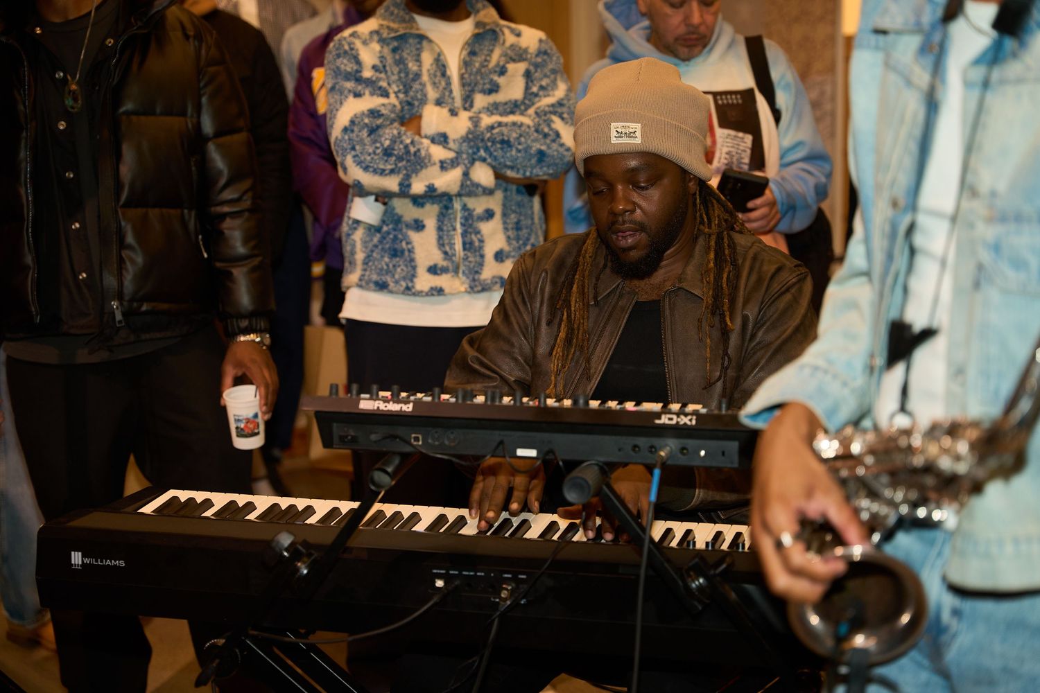 Musicians performing on stage with keyboard instruments and other musical equipment.