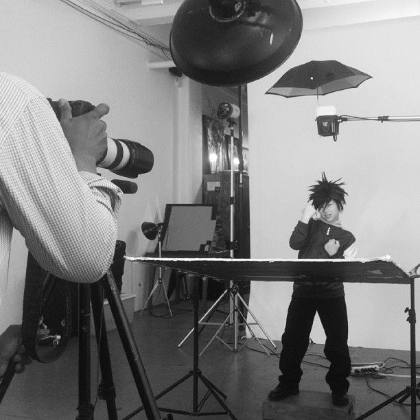Behind the scenes photo shoot setup with photography equipment and lighting in a white studio.