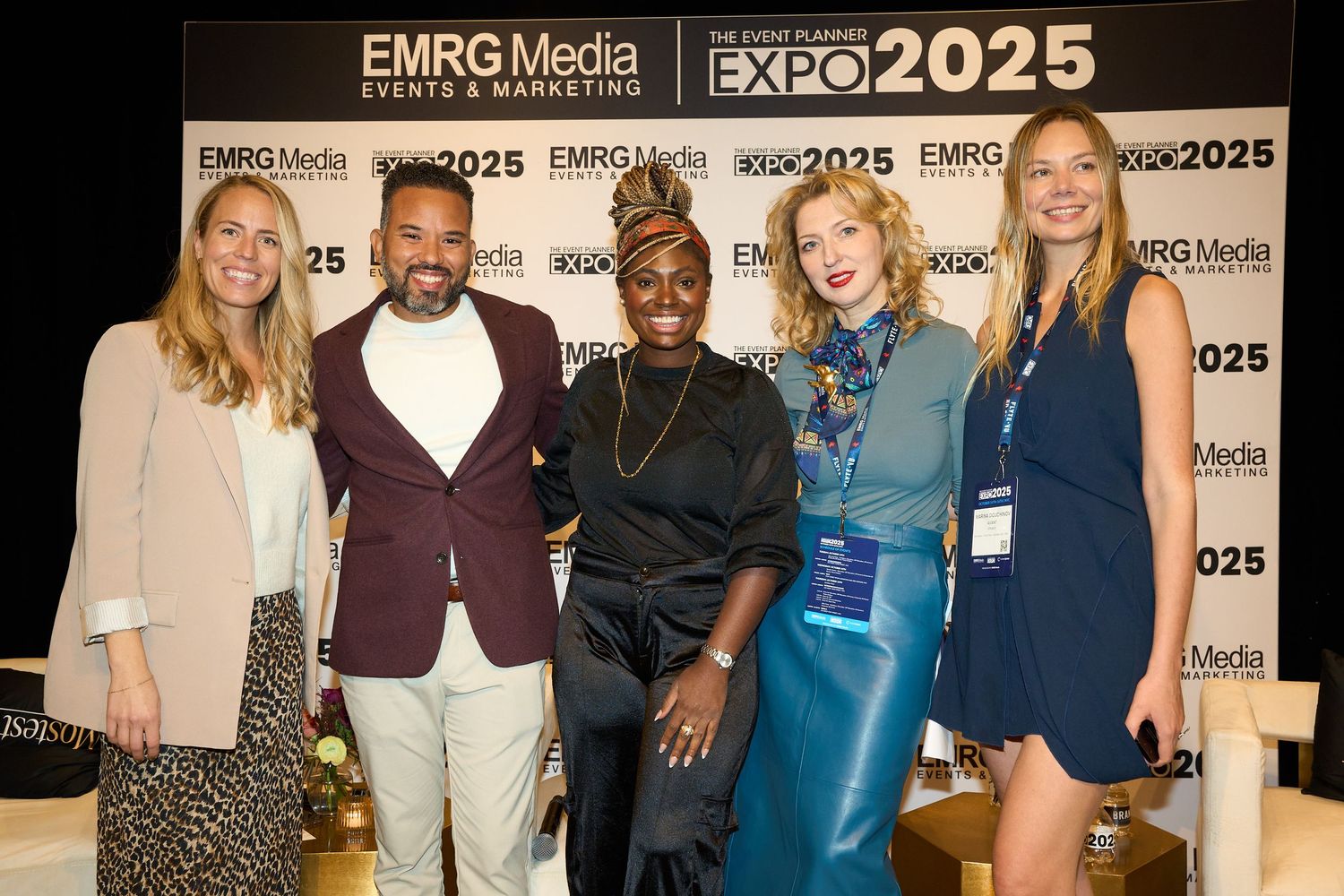 A group of people pose together at the EMRG Media Expo 2025 event in front of a branded backdrop.